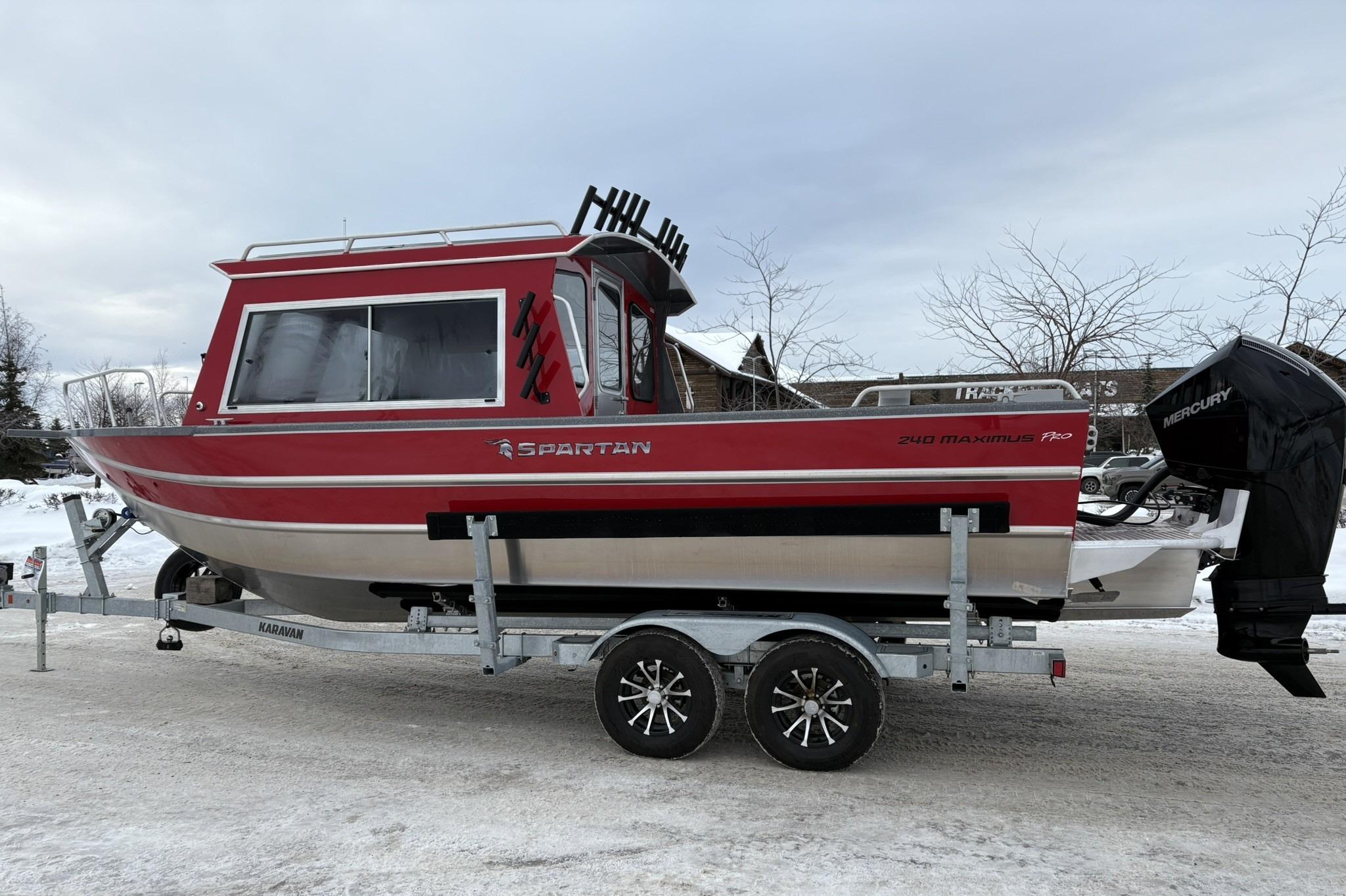 2024 Spartan 240 Maximus Pro boat on trailer, red and silver design, parked on snowy ground.