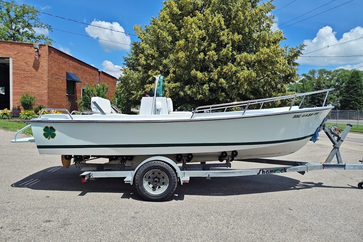 1975 Shamrock 200 Open boat on trailer, parked outdoors near brick building.