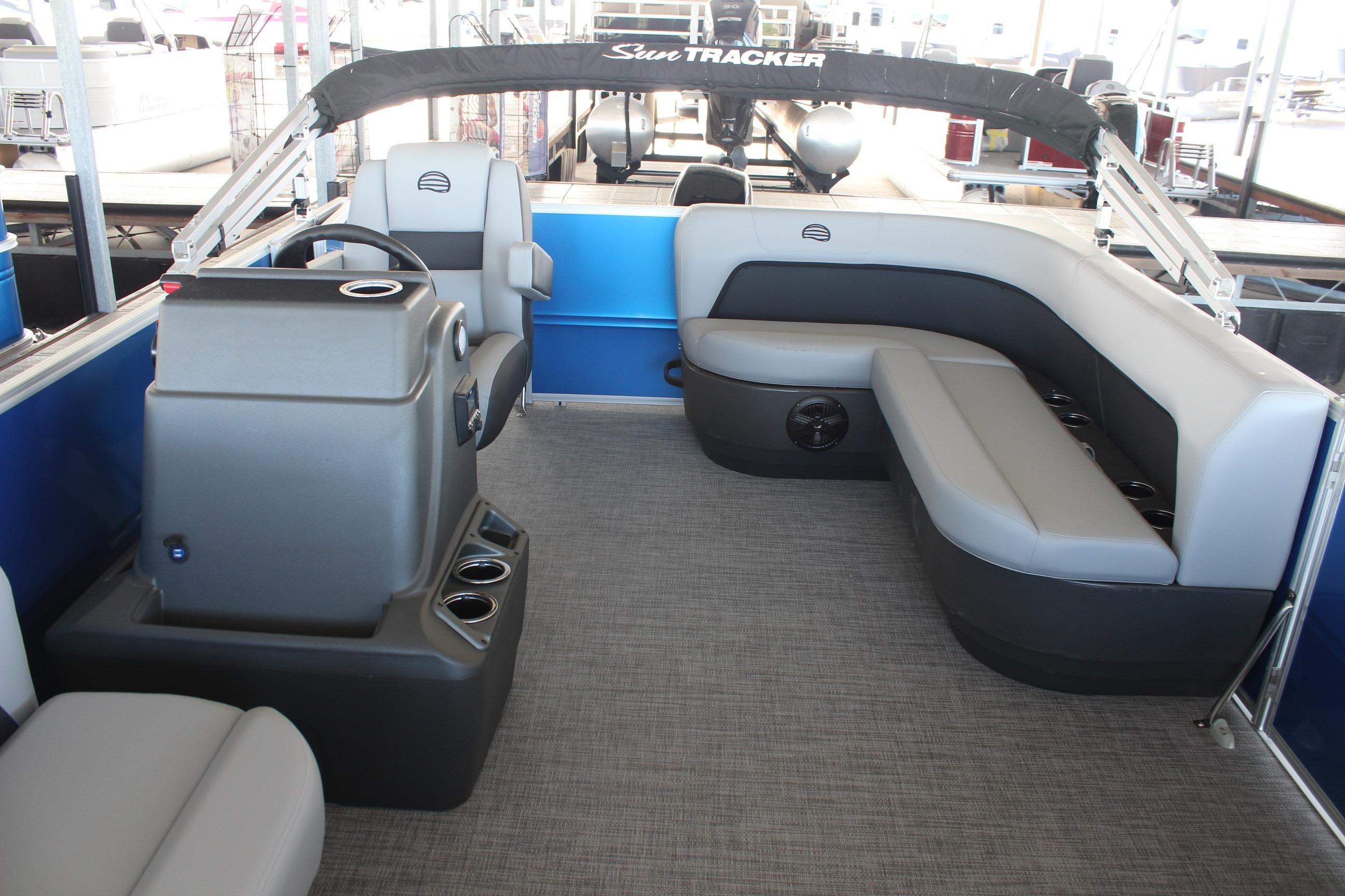 2026 Sun Tracker Party Barge 16 DLX interior with gray seating and steering console.