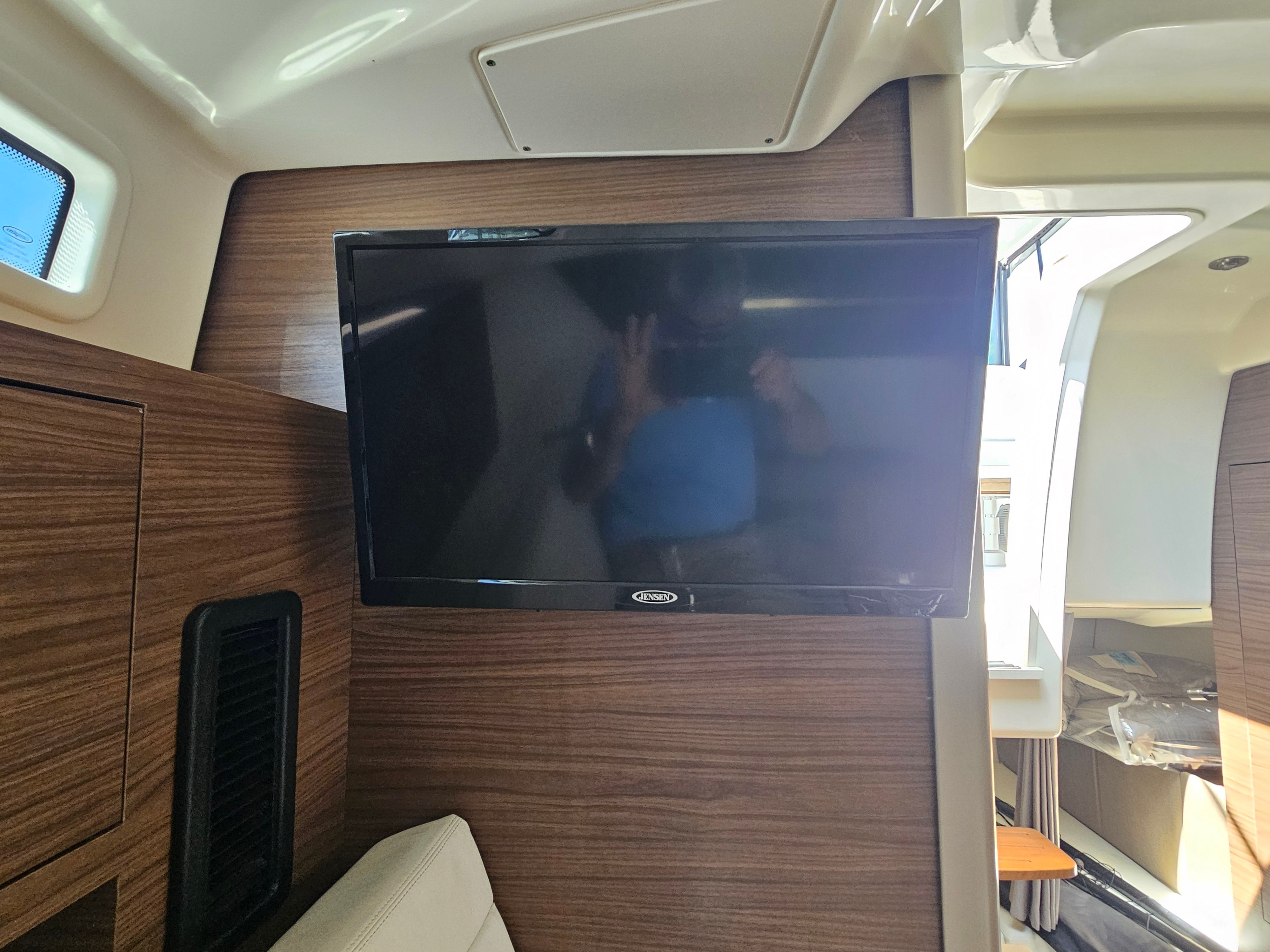 Interior of the Boston Whaler 325 Conquest with a flat-screen TV mounted on the wall.