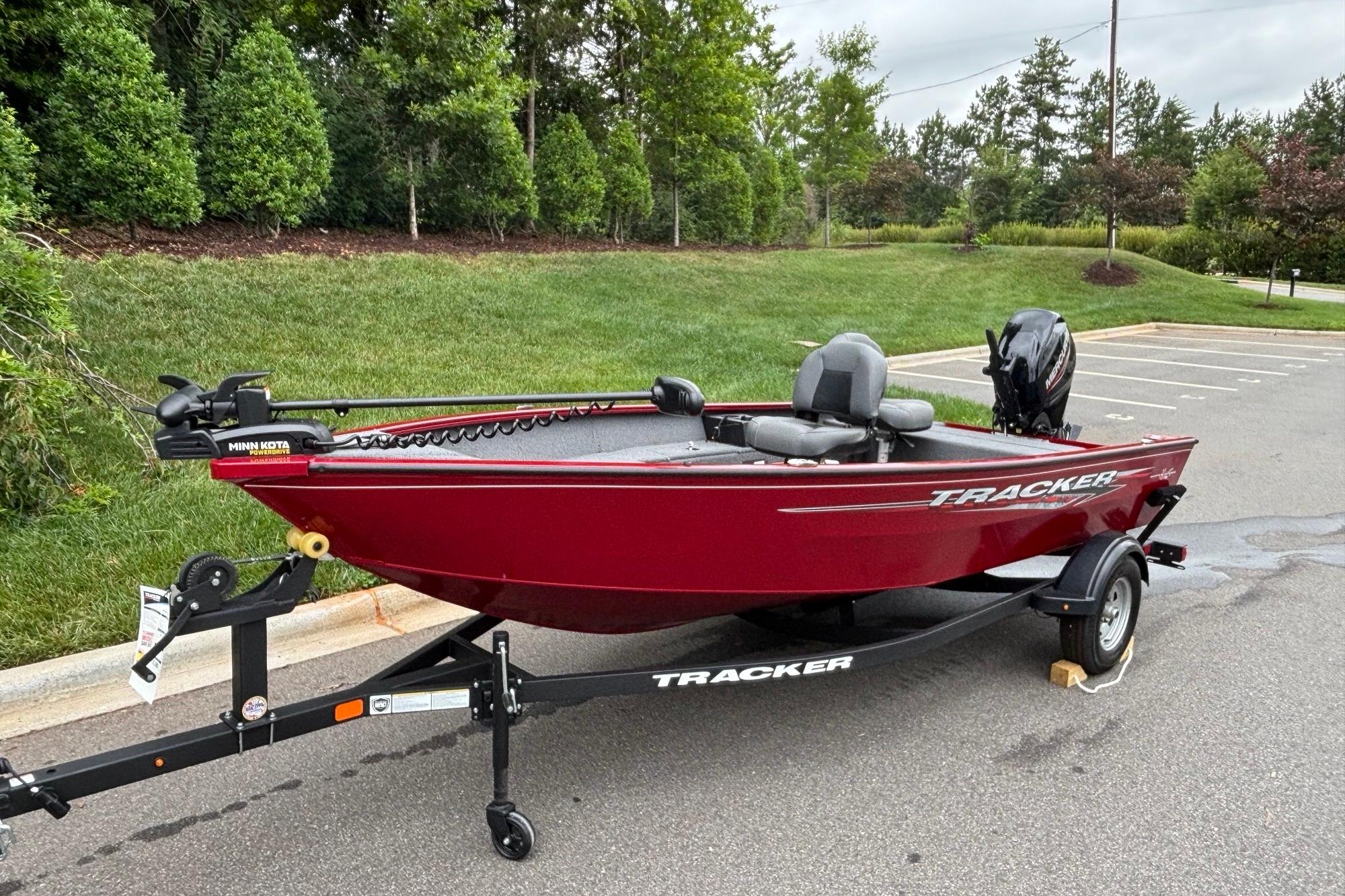 2025 Tracker Super Guide V-16 T boat on trailer, parked outdoors.