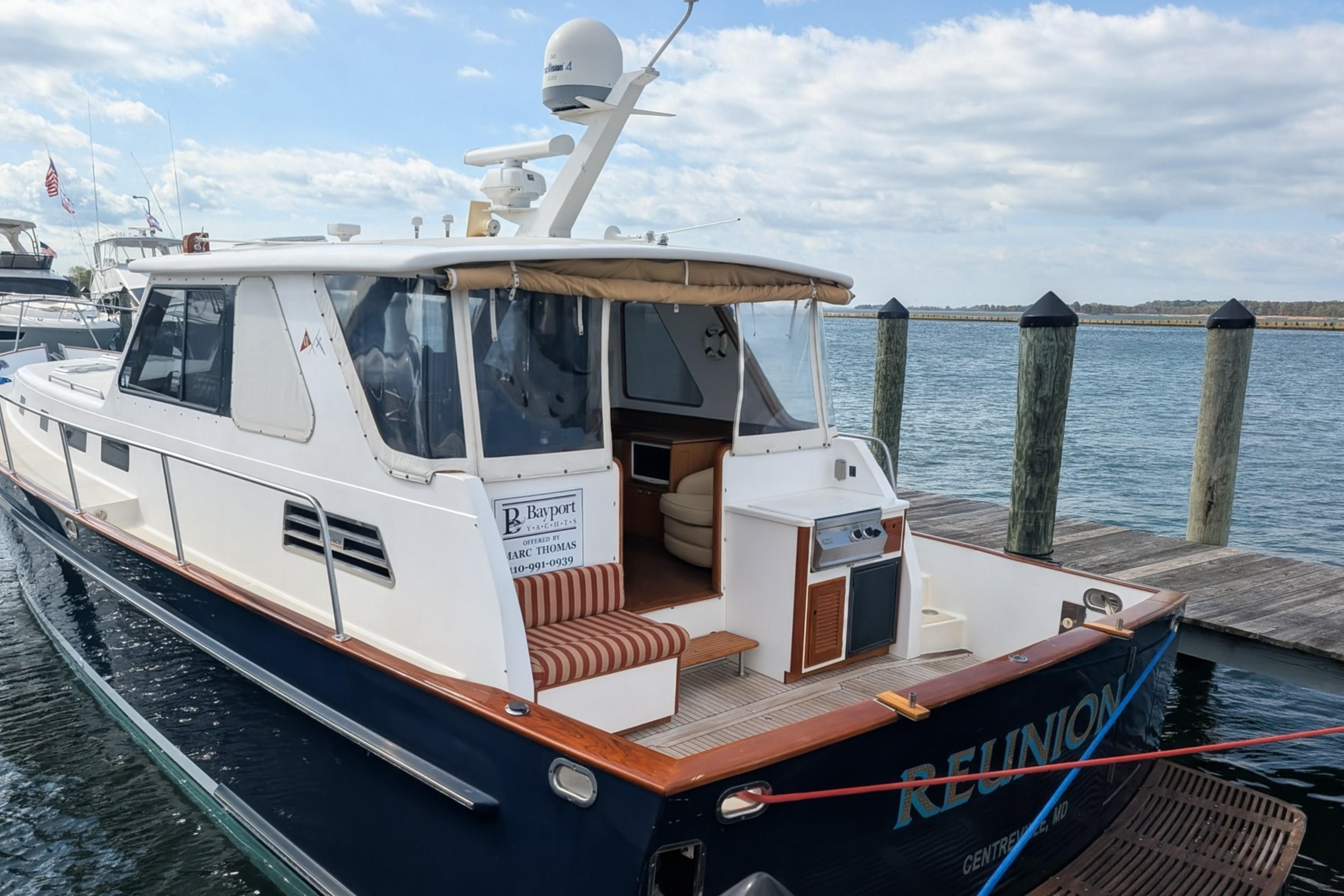 2002 Legacy Yachts 52 Express docked, featuring spacious deck and elegant design.