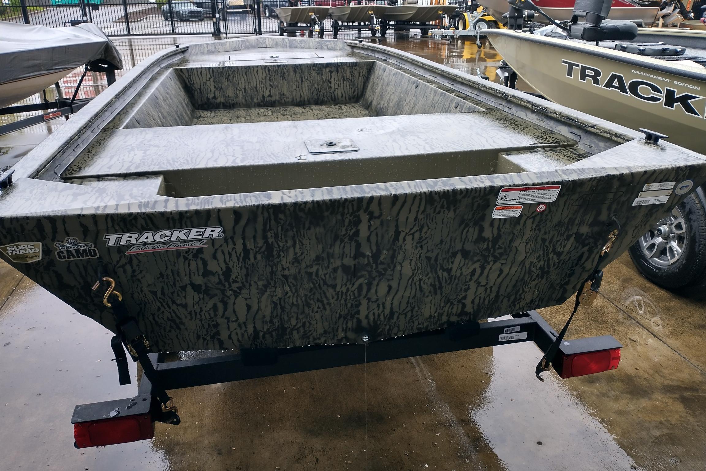 2026 Tracker Grizzly 1648 Utility boat on trailer, camo design, parked outdoors.
