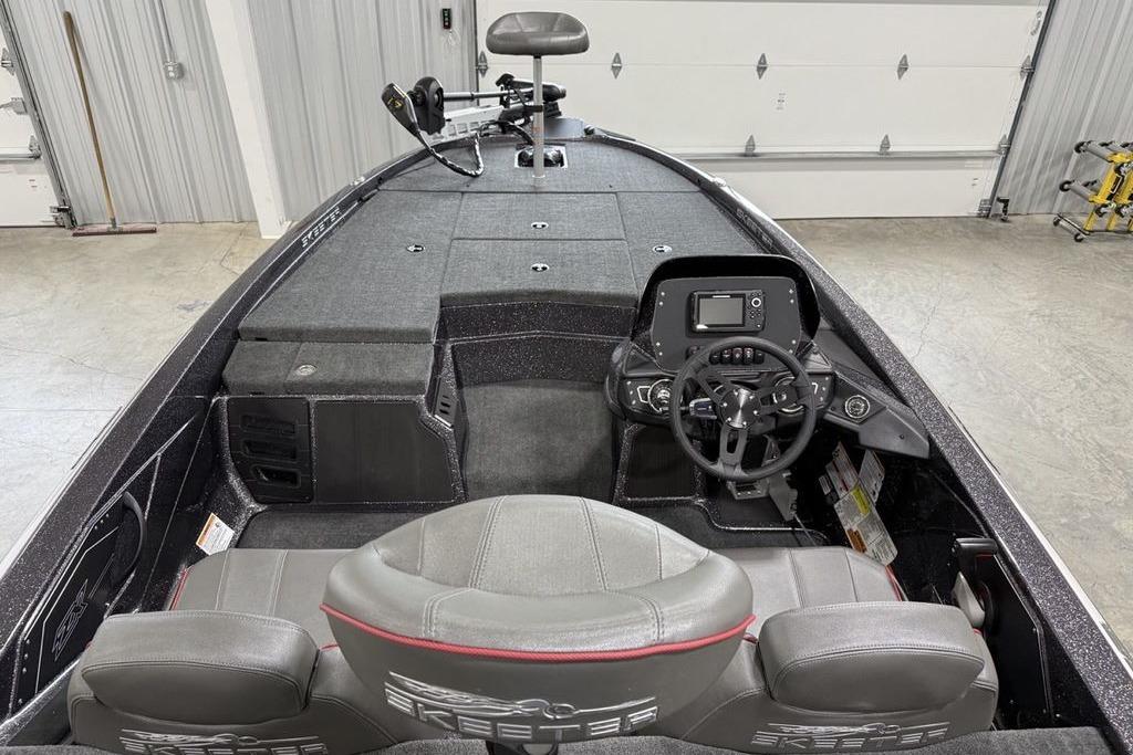 2025 Skeeter ZX150 boat interior with steering console and seating in a garage.