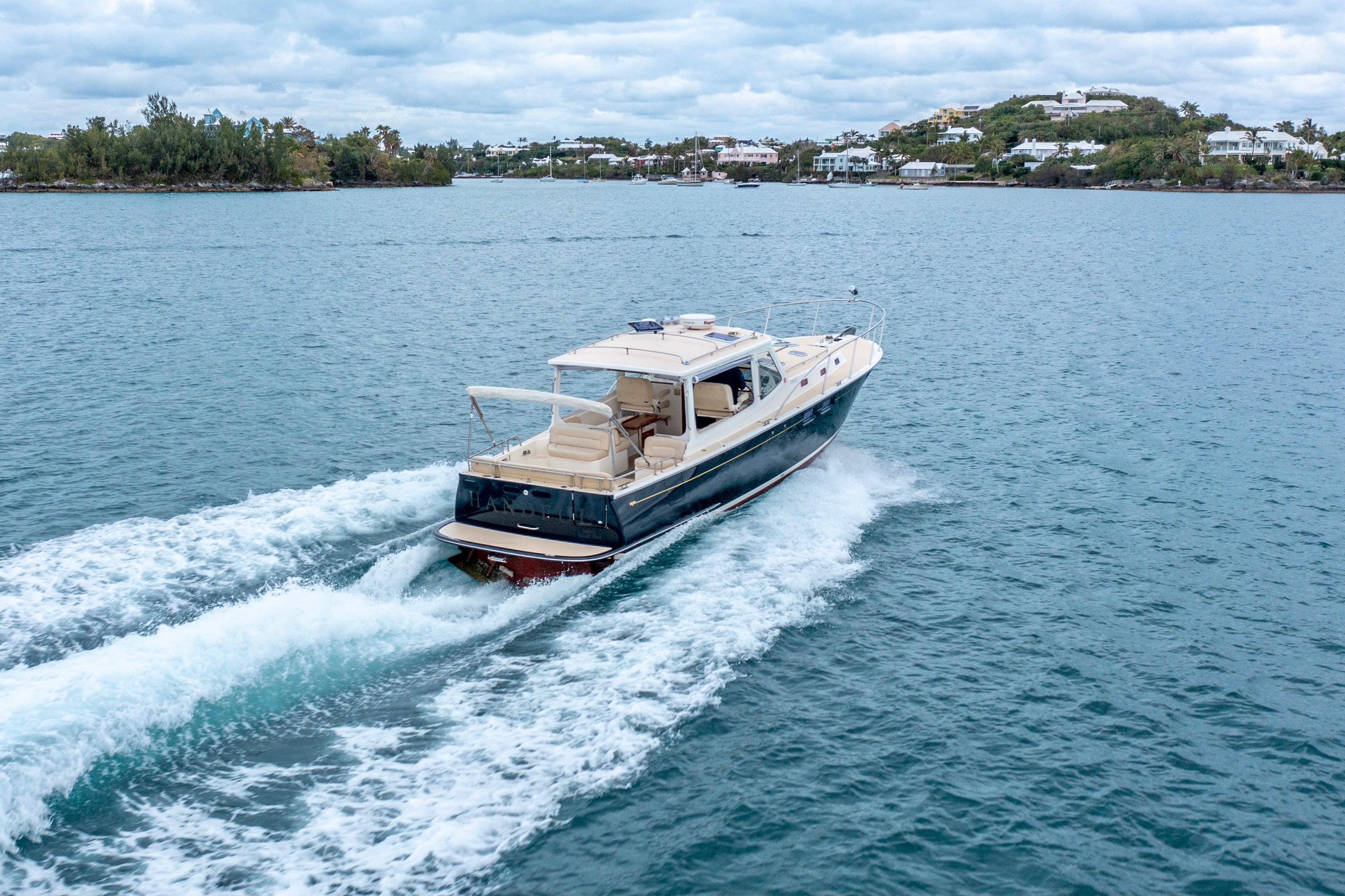 2014 MJM 40z yacht cruising on a scenic blue waterway.