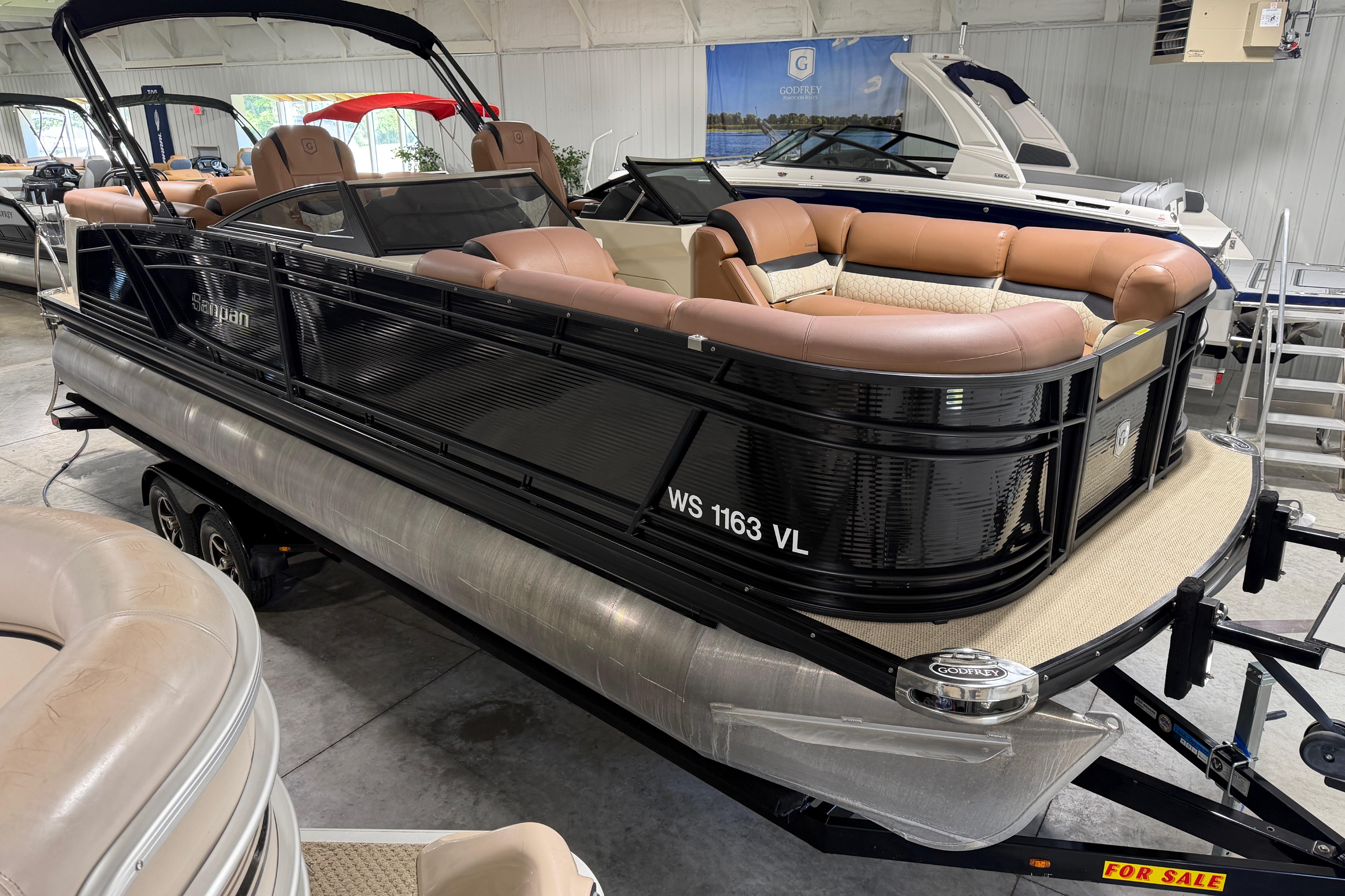 2018 Godfrey Sanpan 2500 ULC pontoon boat with tan seating, displayed indoors for sale.