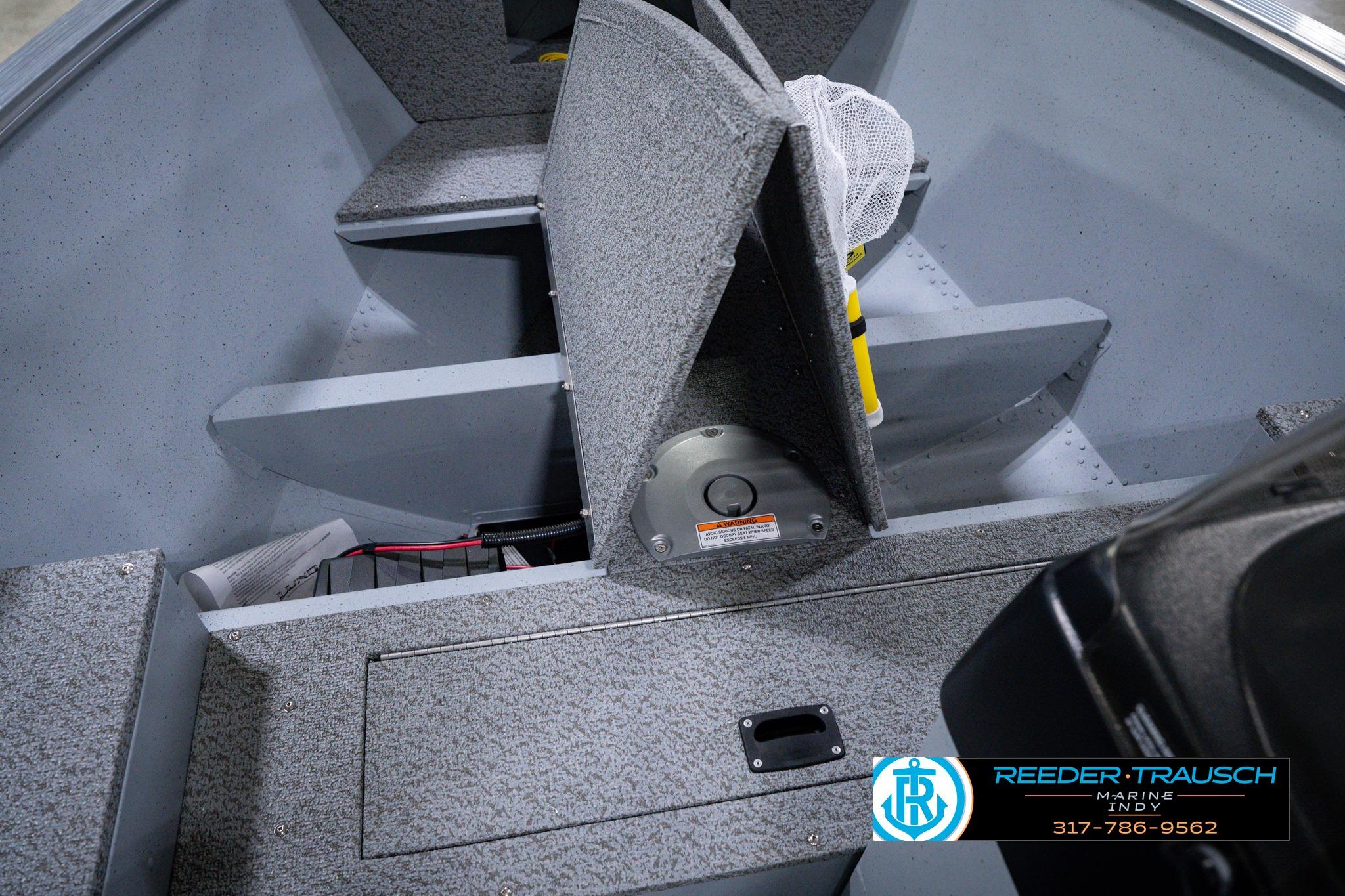 Interior of 2026 Lund 1600 Fury SS boat with storage compartments and carpeted flooring.