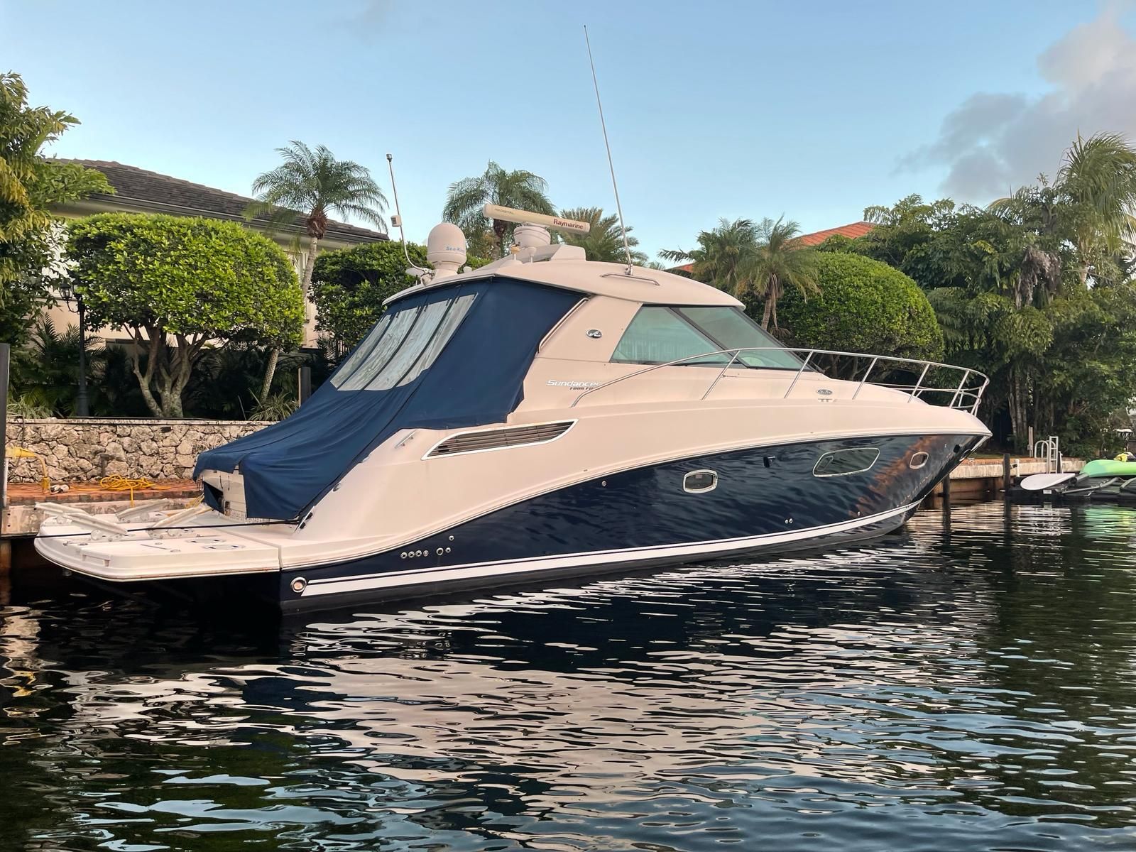 2010 Sea Ray 450 yacht docked, surrounded by lush greenery.