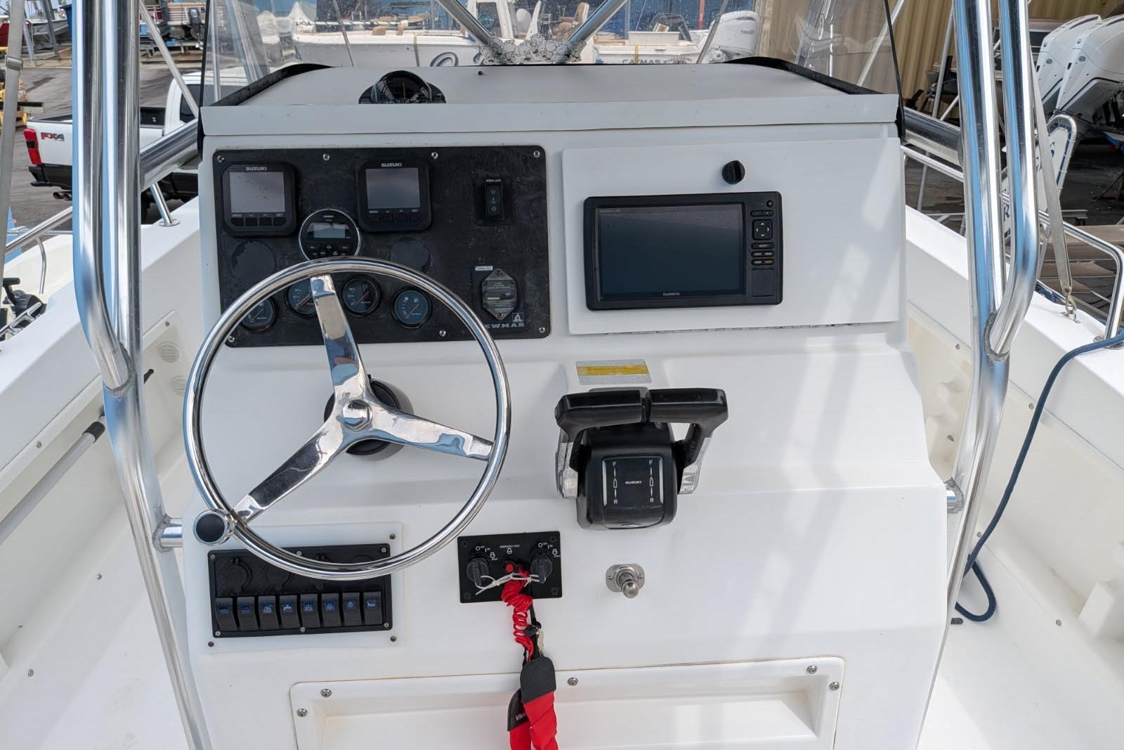2002 Pro Sports 2200 CC ProKat boat dashboard with steering wheel and navigation controls.