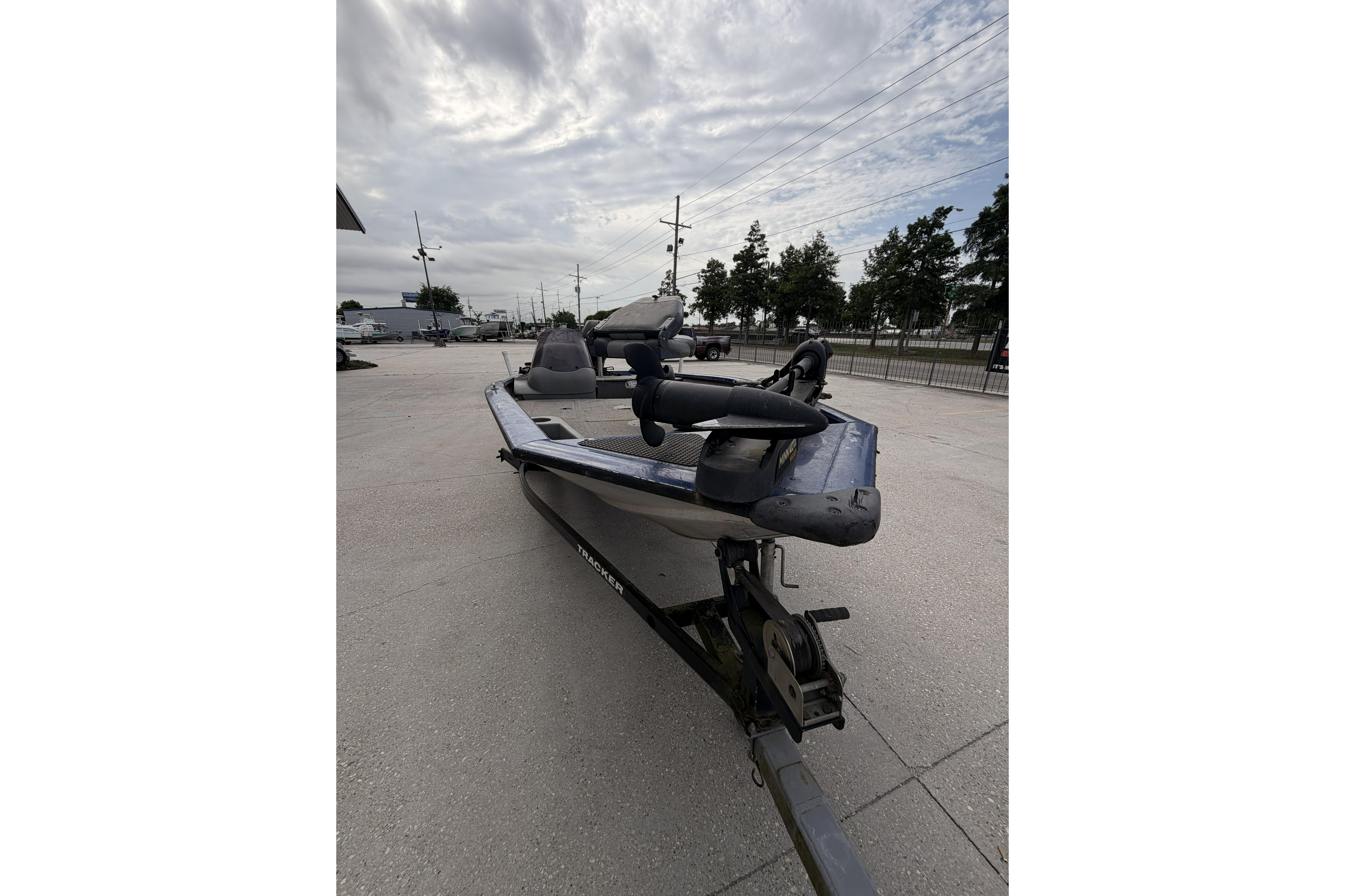 2012 Bass Tracker Pro 17 boat on trailer, parked outdoors under cloudy sky.