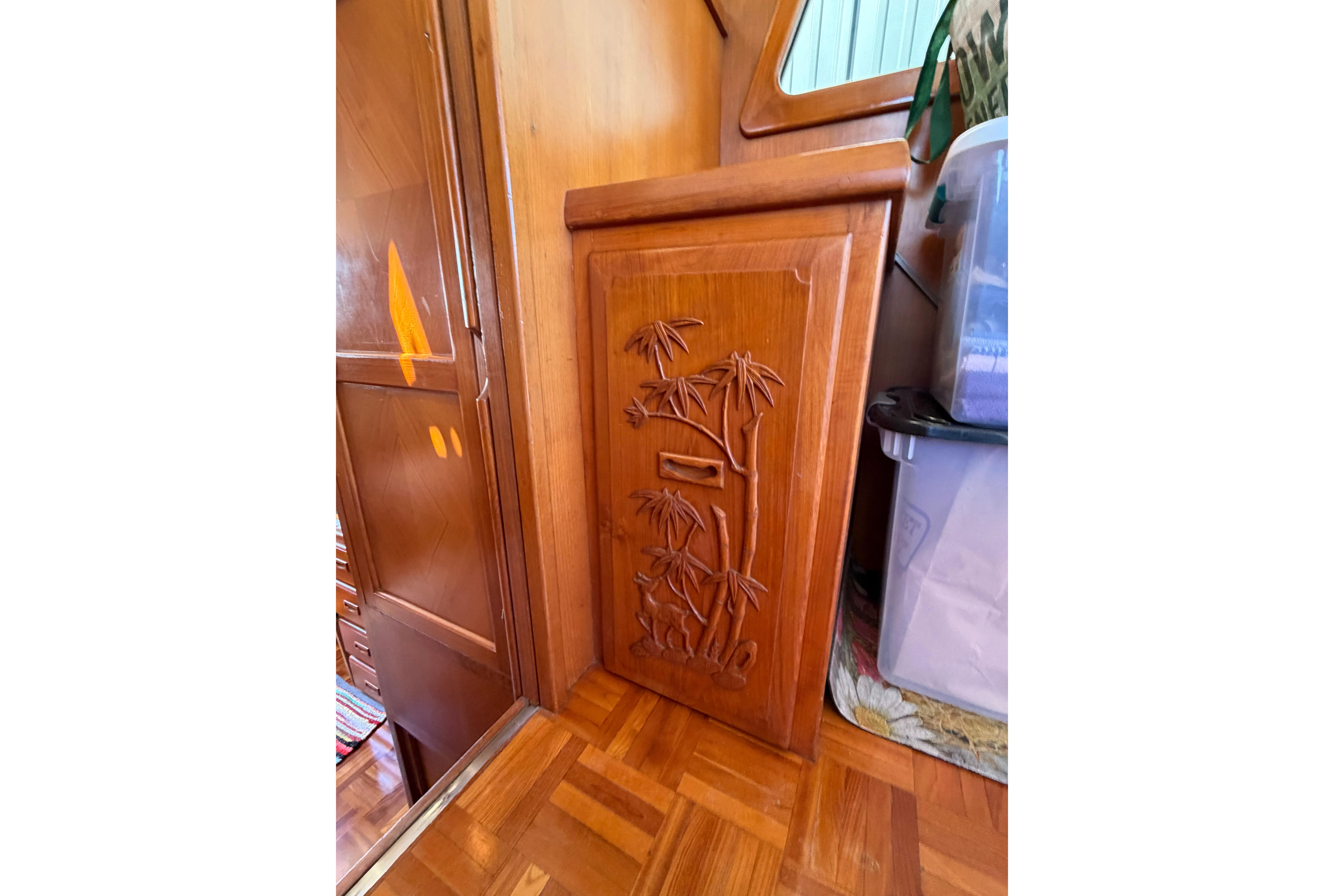 Wooden cabinet with bamboo carving inside 1987 Marine Trader 36 boat interior.