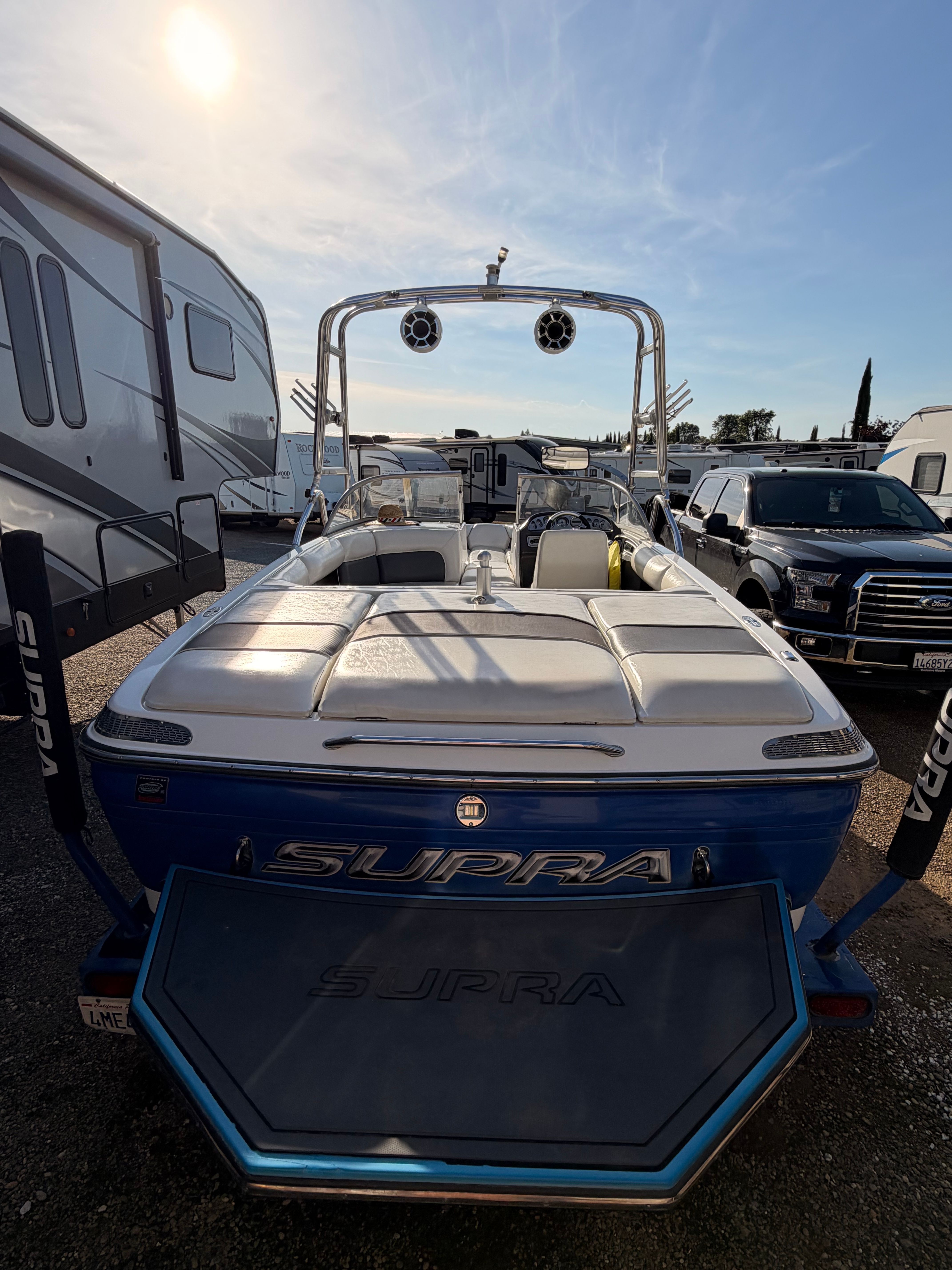 2004 Supra Launch SSV boat parked under sunset sky.