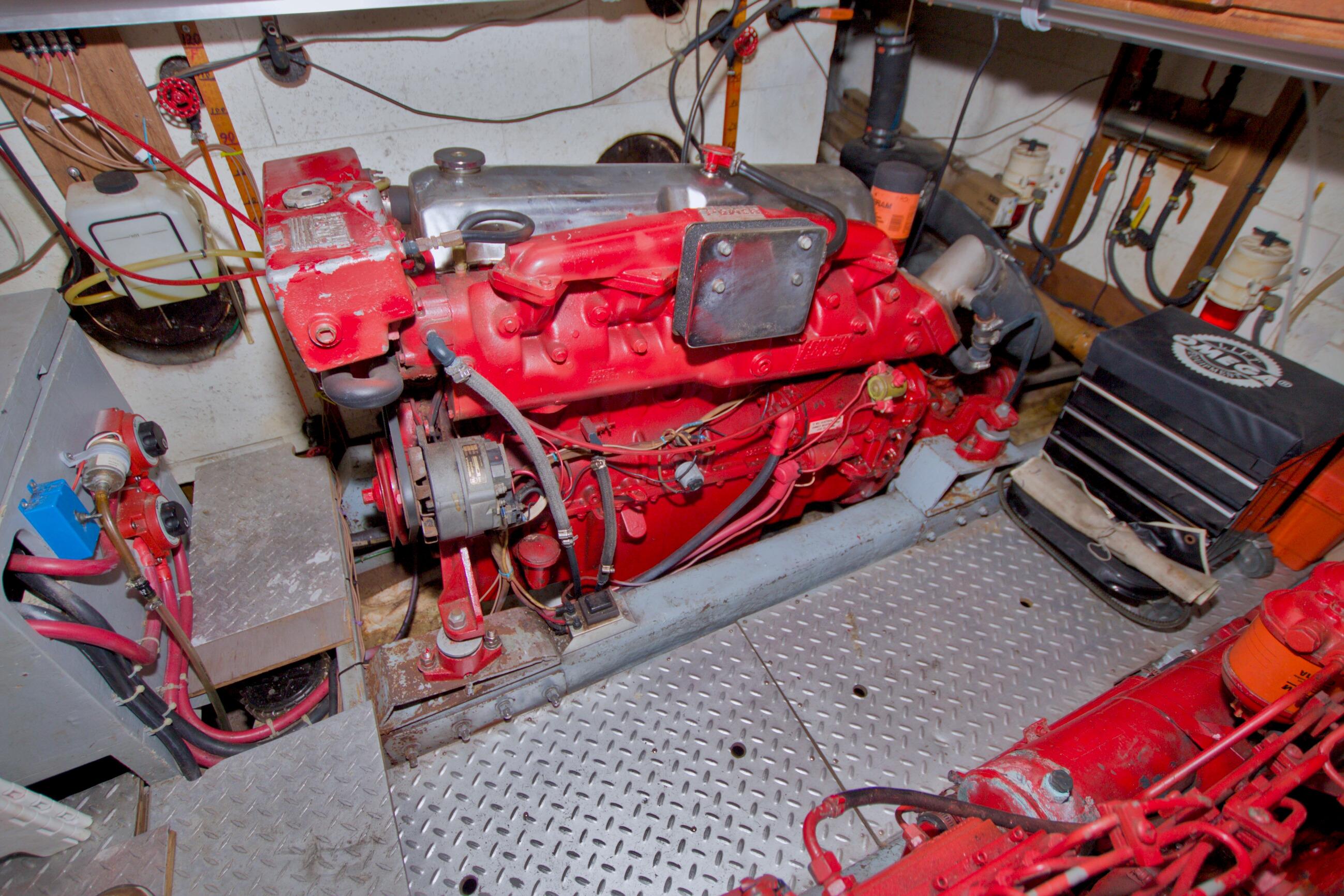 Engine room of a 1984 Present Yachts 42 Sundeck, featuring a red marine engine.