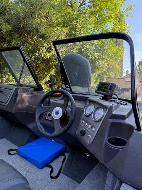 The image shows the cockpit of a 2023 Tracker PGV16WT 16 boat with steering and instruments.