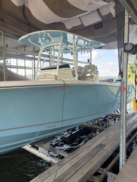 A light blue 2018 NauticStar boat is docked under a covered area.