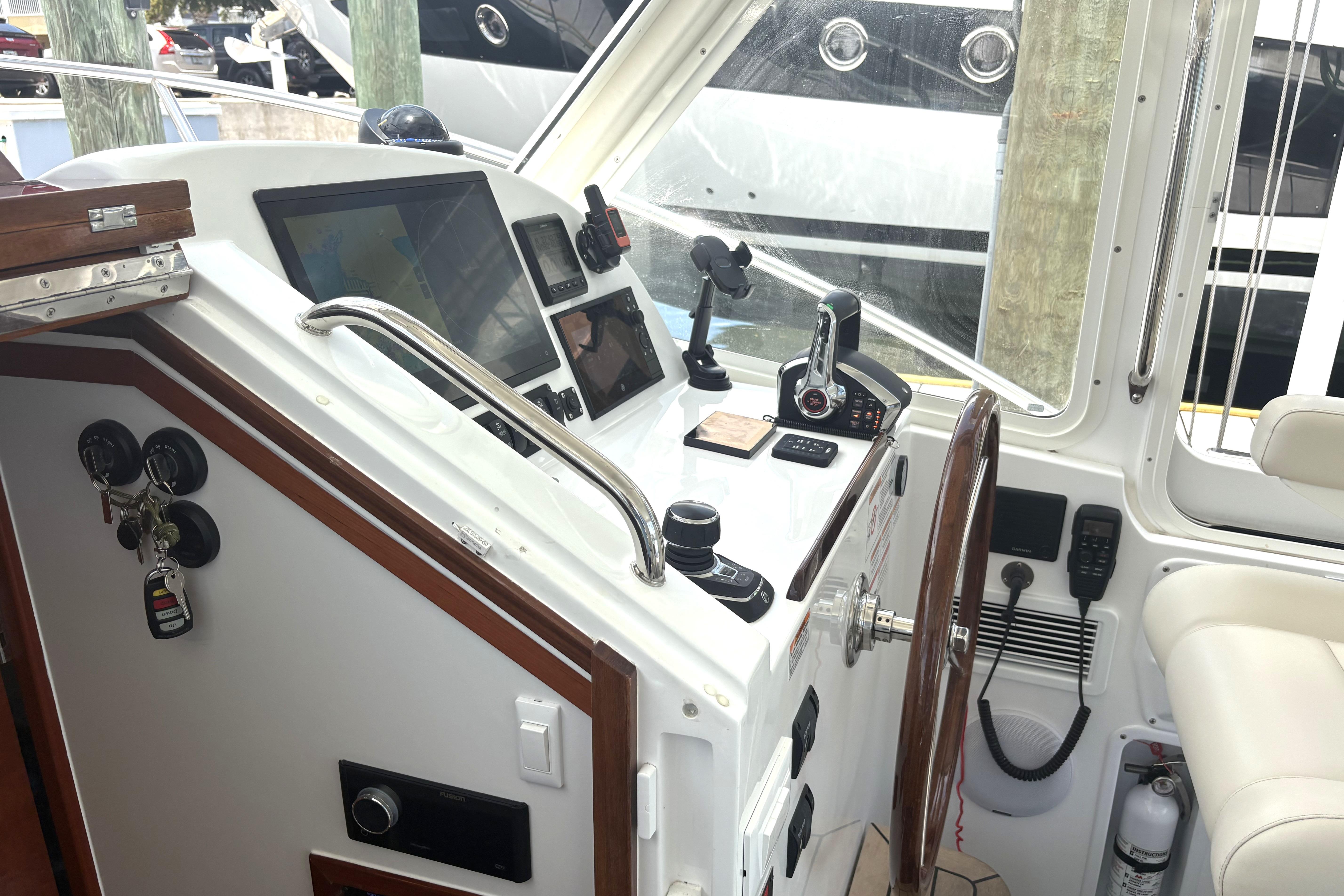 2024 MJM 35z boat cockpit with modern navigation controls and steering wheel.