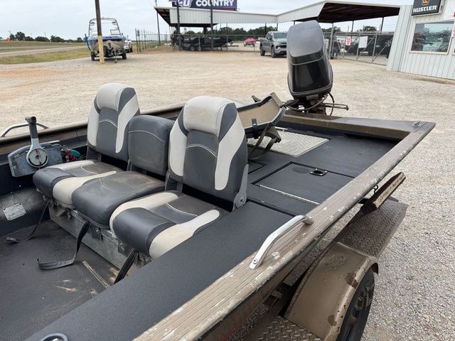 2001 Xpress X51 boat with three seats and steering wheel, parked outdoors.