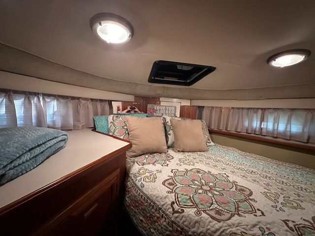 Interior of Carver 3807 Yacht, cozy bedroom with bed and pillows.