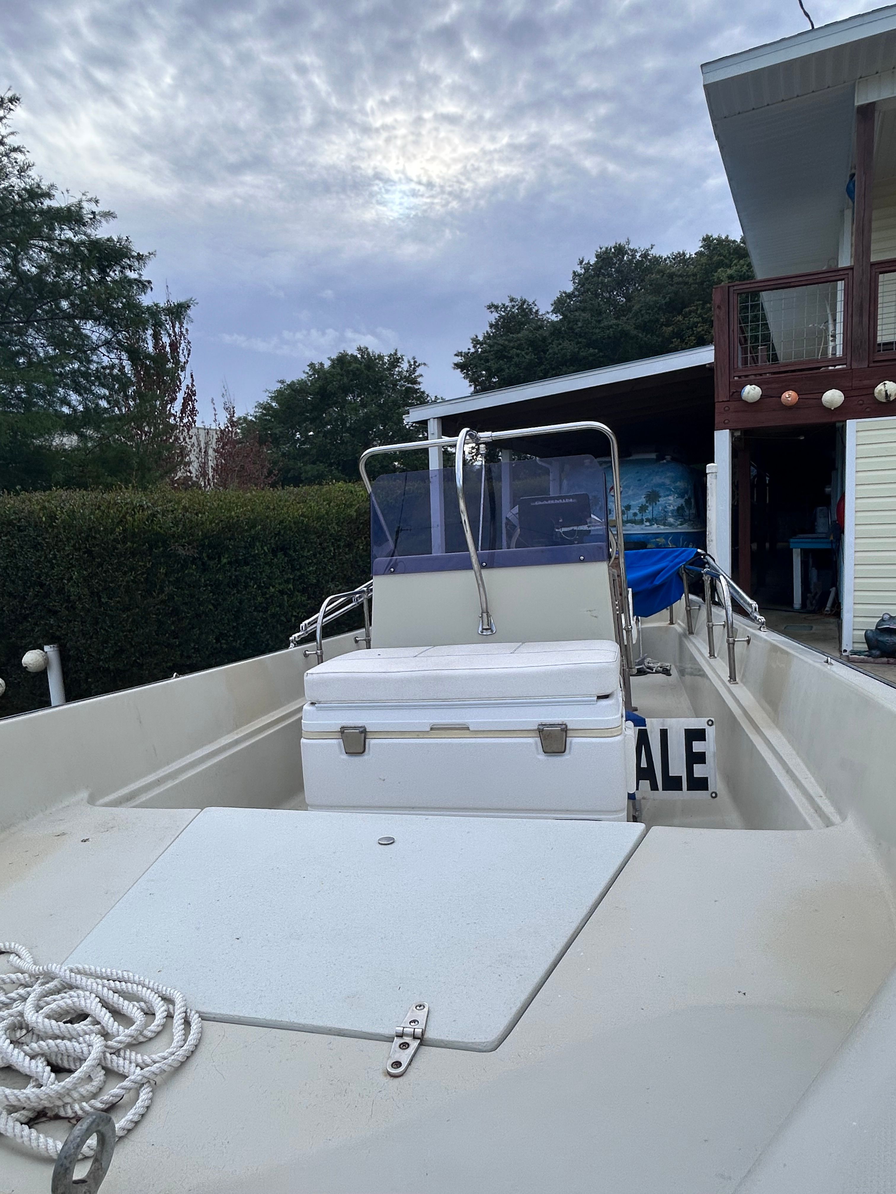 A 1984 Boston Whaler MONTAUK on a property. It features an open deck and a steering console.
