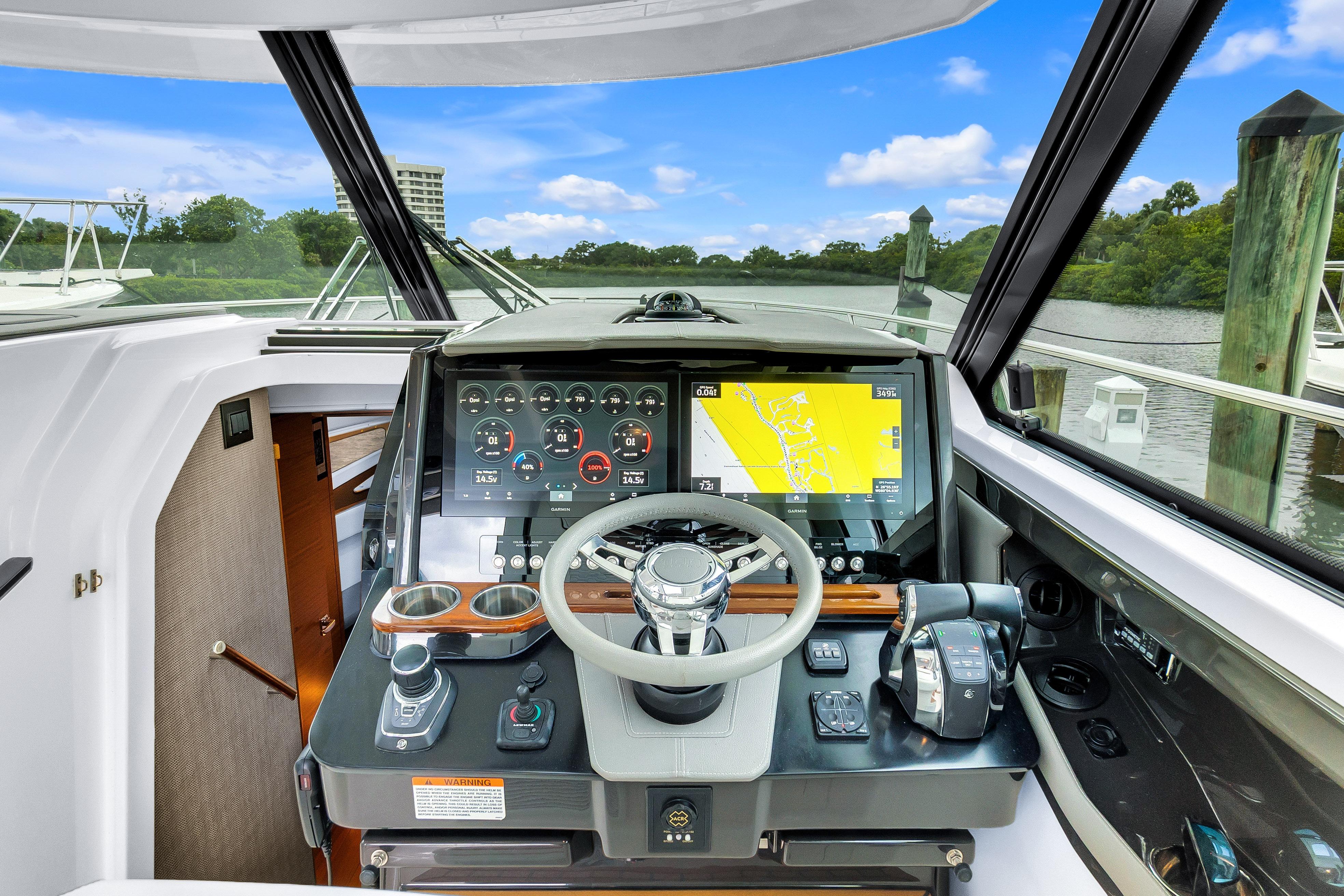 2021 Tiara Sport 43 LE helm with advanced navigation system and scenic marina view.