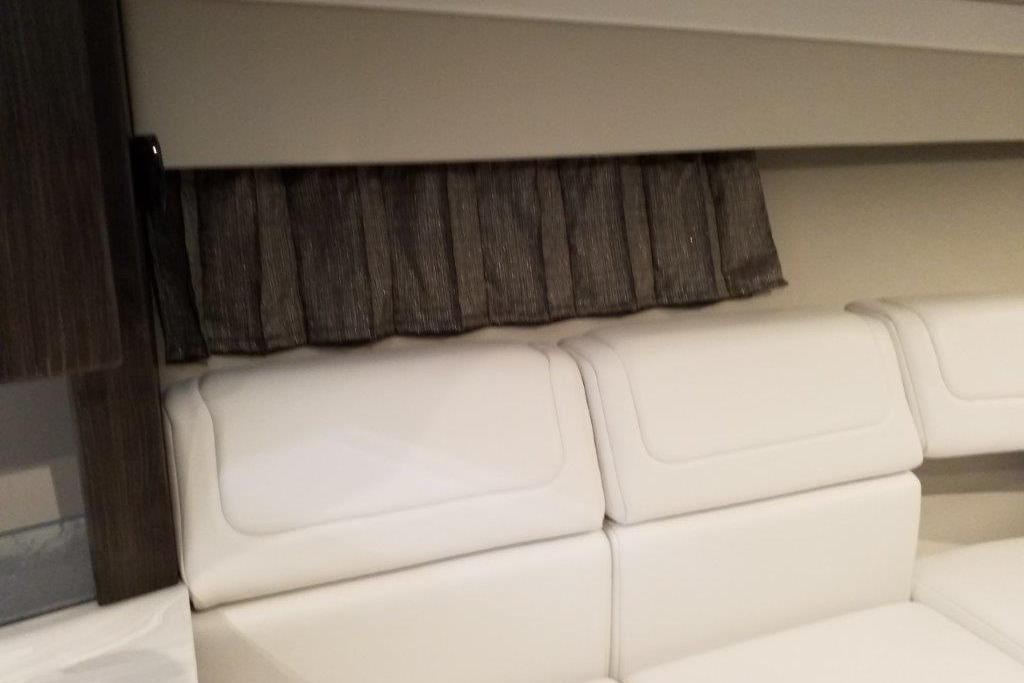 Interior of 2021 Formula 350 Sun Sport with white seating and dark curtains.