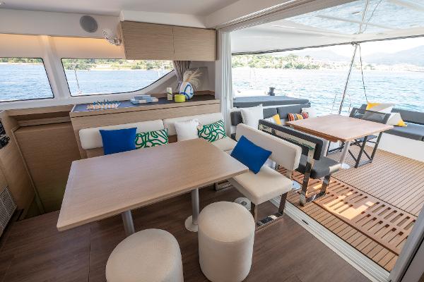 Modern Lagoon 43 yacht interior with dining area, stylish seating, and ocean view, 2025 model.