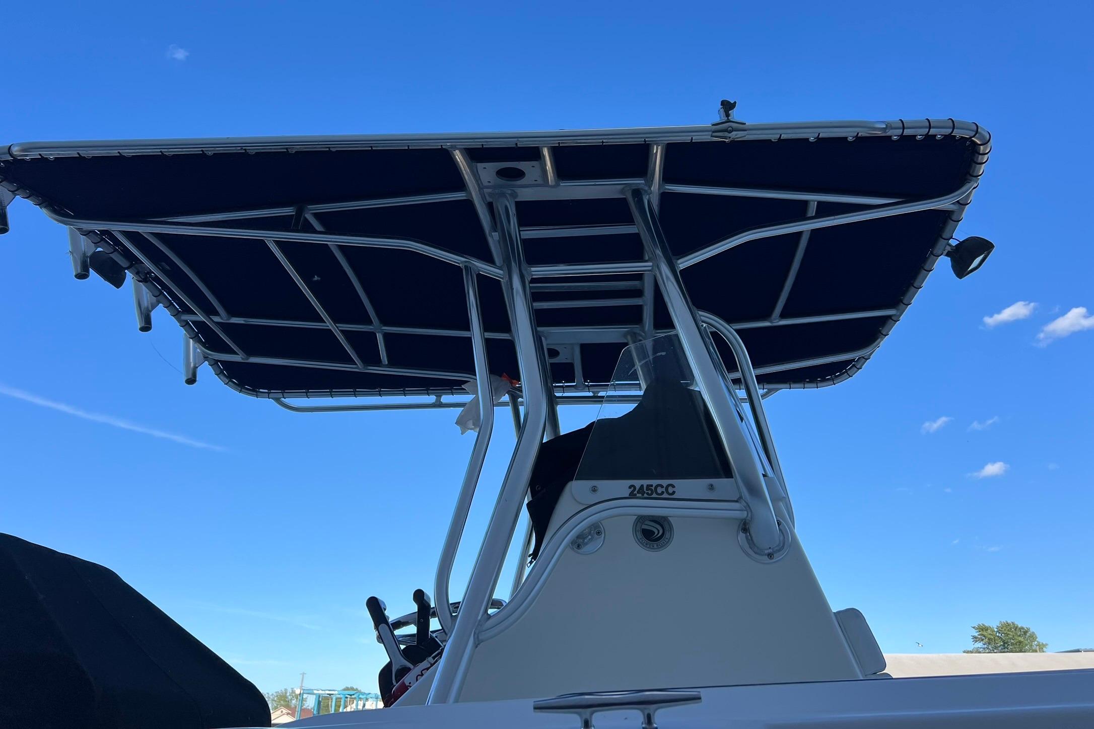 2006 Edgewater 245CC boat with T-top against clear blue sky.
