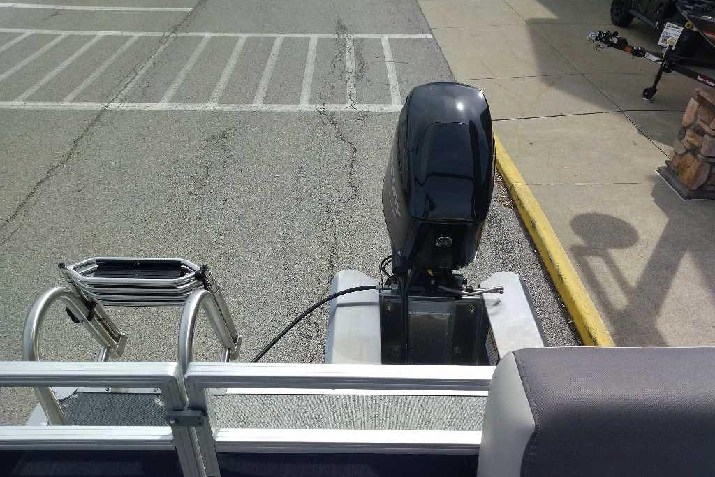 2026 Sun Tracker Bass Buggy 16 XL Select pontoon boat with outboard motor in parking lot.