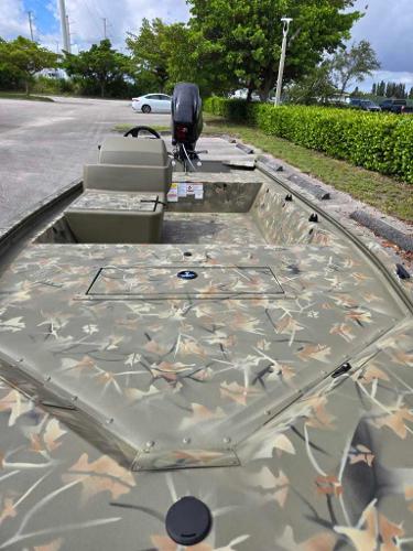 2025 Tracker Grizzly 1648 SC boat with camouflage design in a parking area.