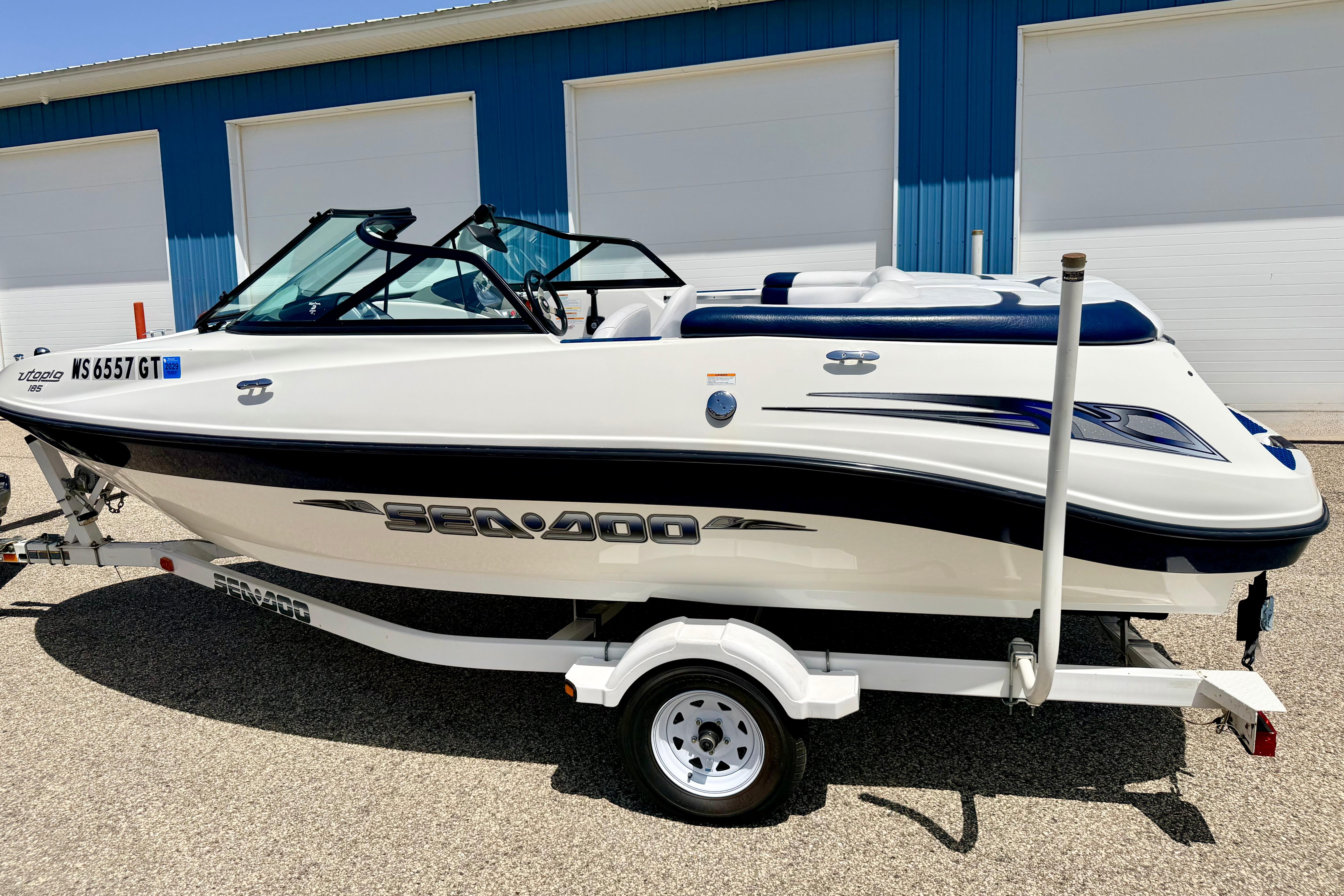 2004 Bombardier SEADOO Utopia 185 boat on trailer, parked outdoors.
