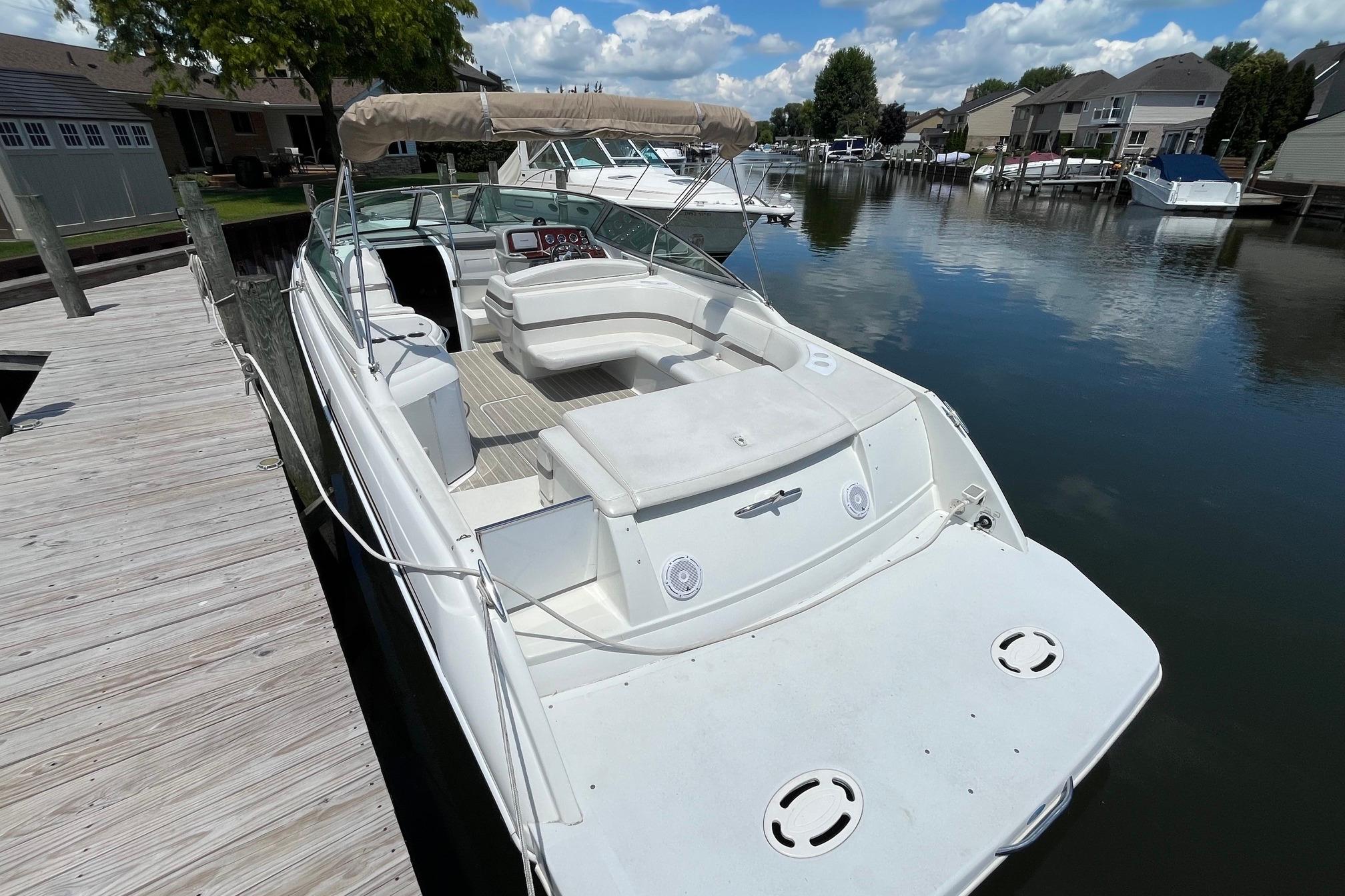 2002 Formula 330 Sun Sport boat docked on a calm waterfront with clear skies.