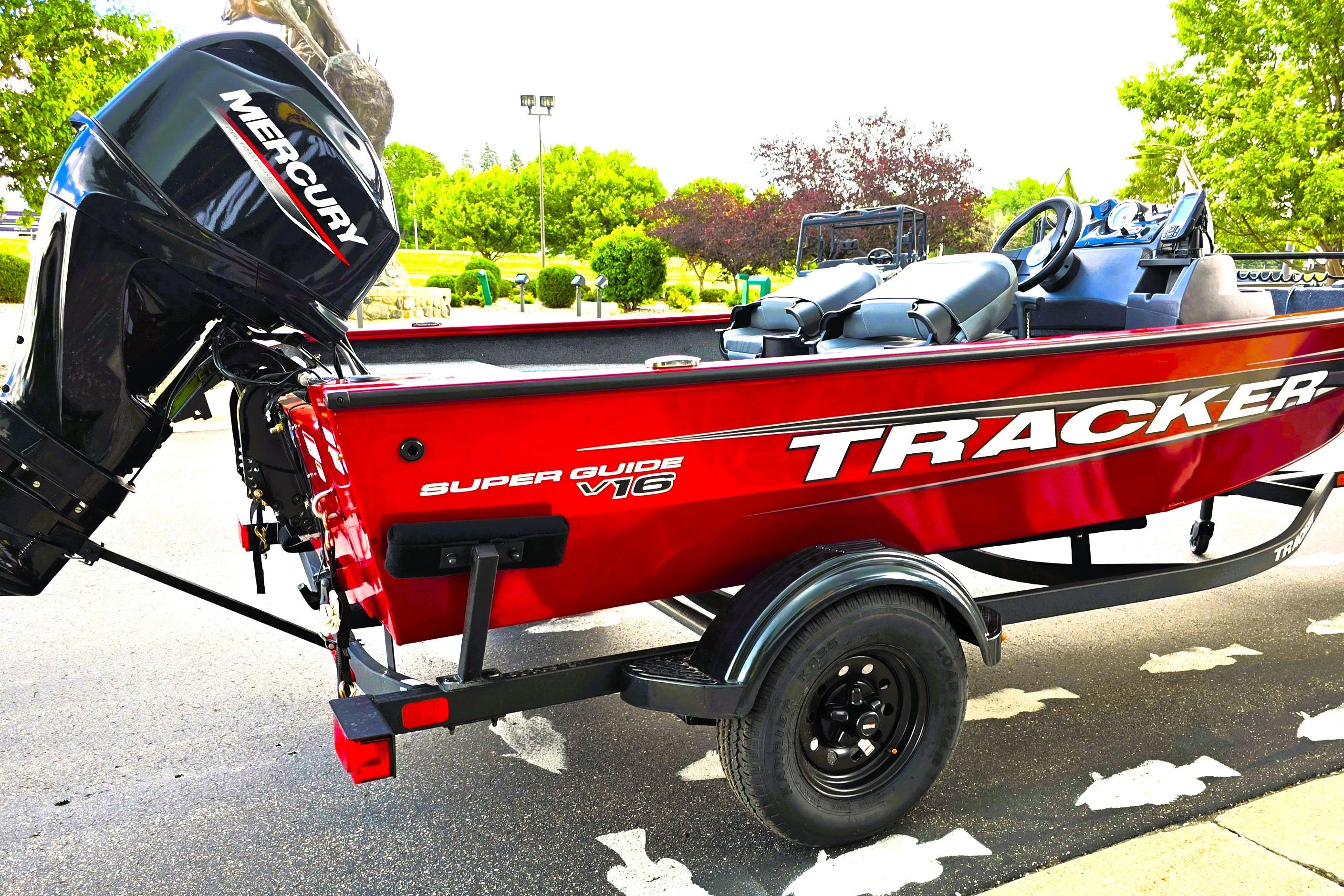 2026 Tracker Super Guide V-16 SC boat with Mercury engine, parked outdoors.
