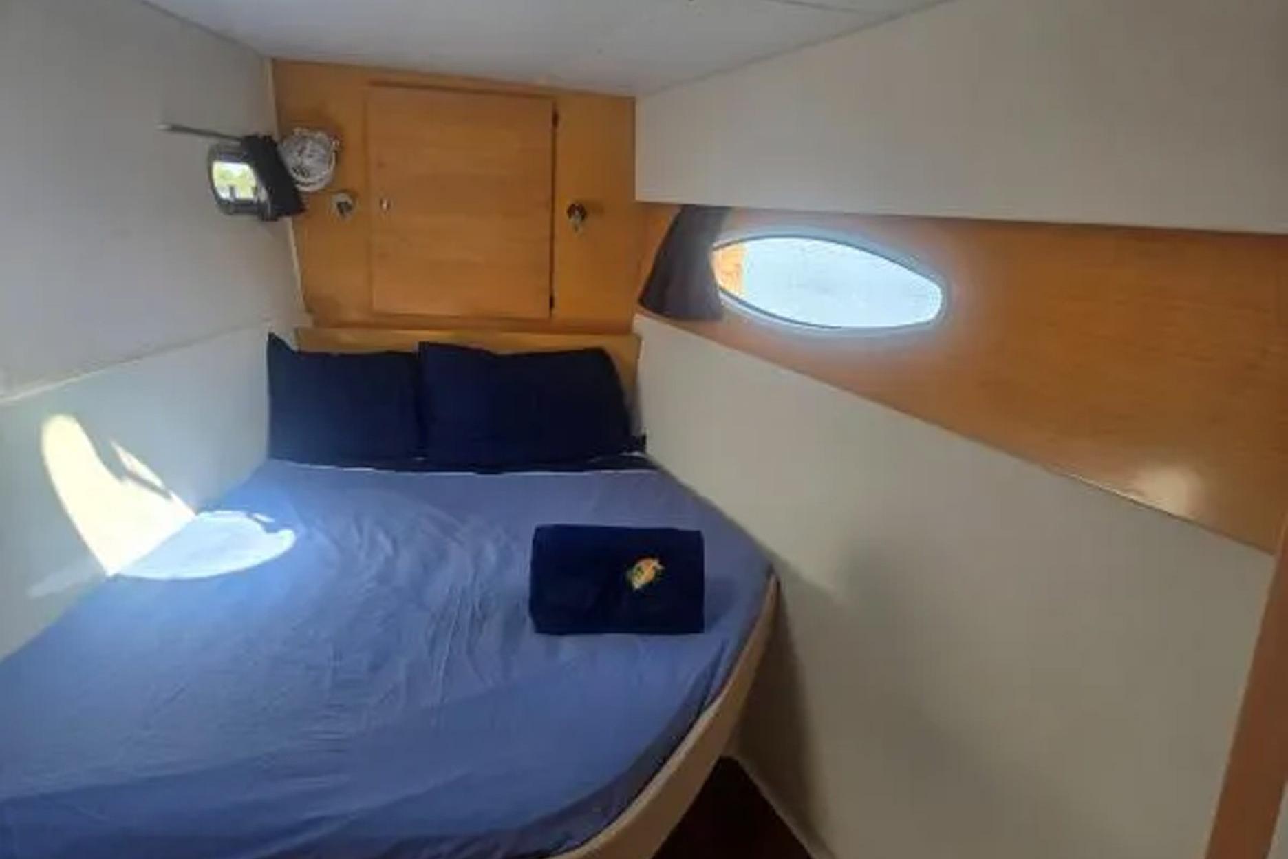 Cozy cabin interior of 2008 Fountaine Pajot Salina 48 catamaran with blue bedding.