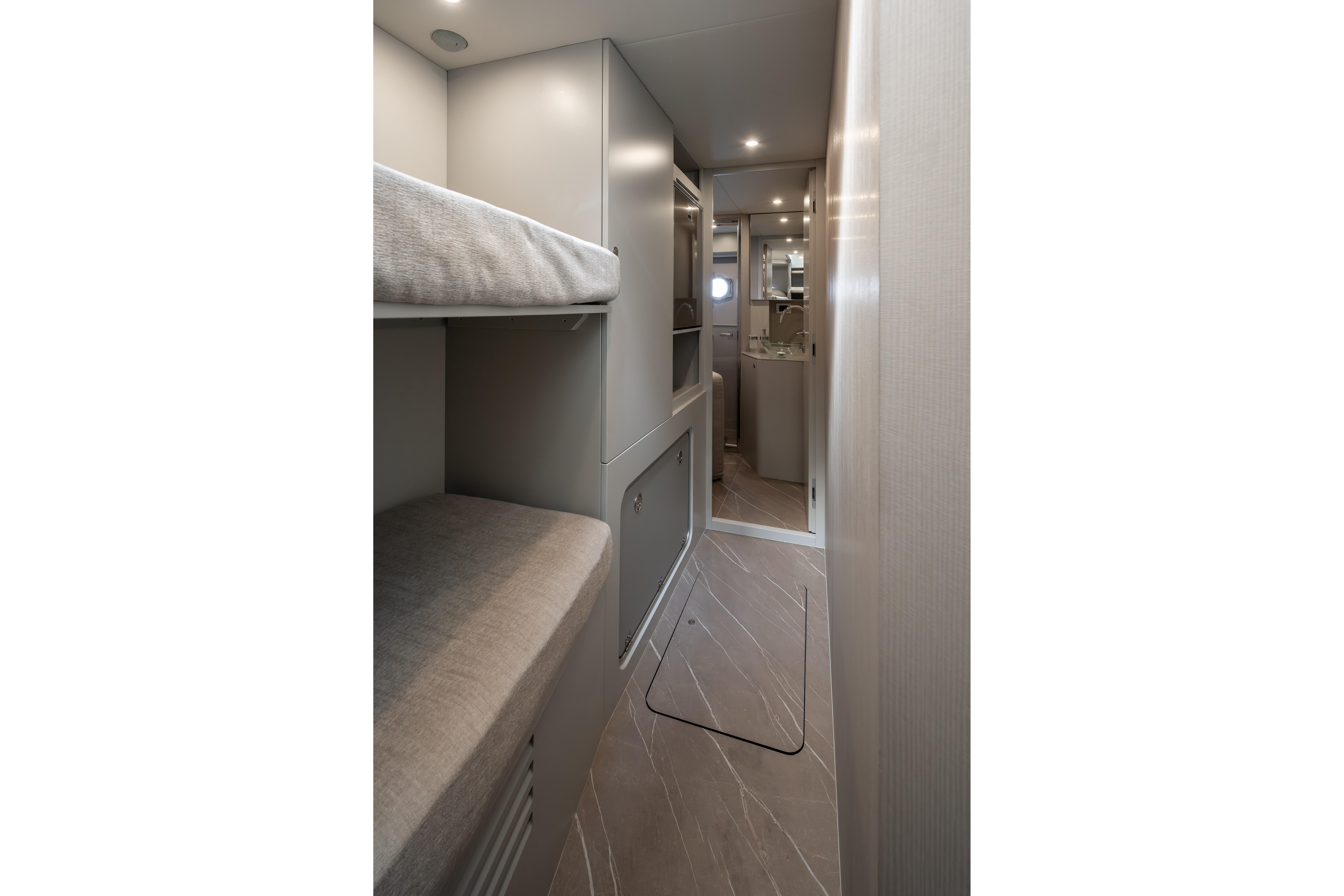 Interior of a modern boat with bunk beds and a bathroom.