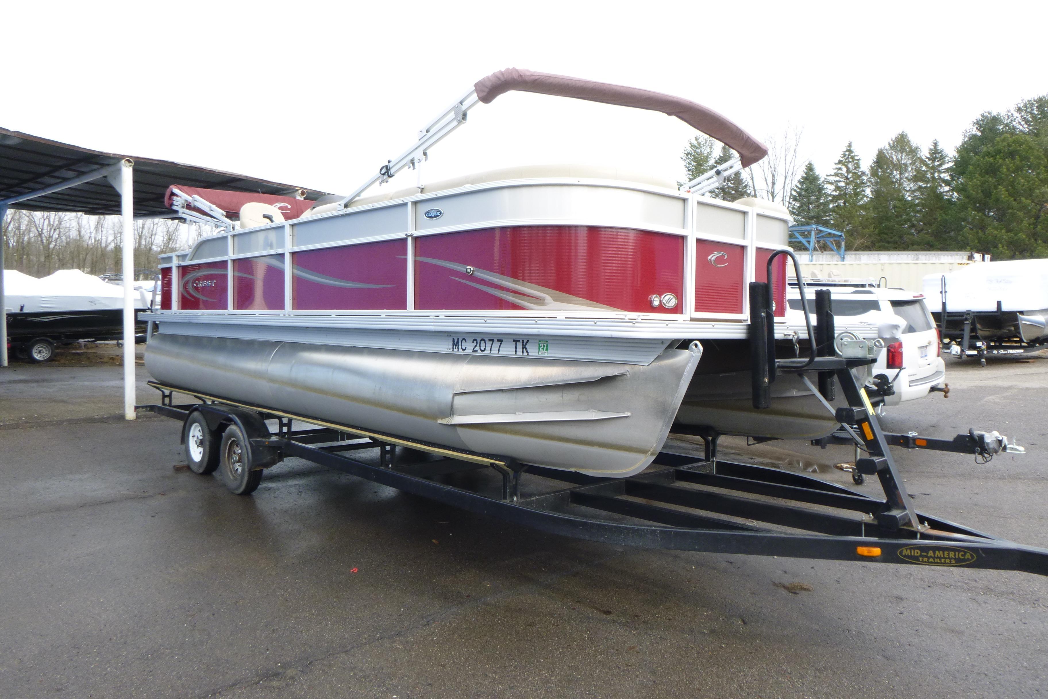 2012 Crest 230SLR Classic pontoon boat on trailer, parked outdoors.