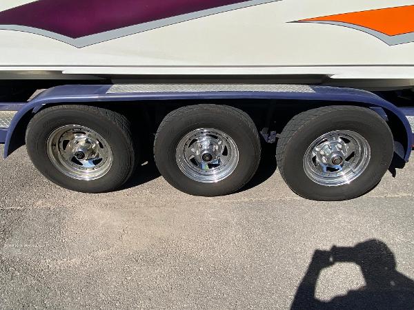 Triple axle trailer of a 2002 Advantage Victory boat with chrome wheels.