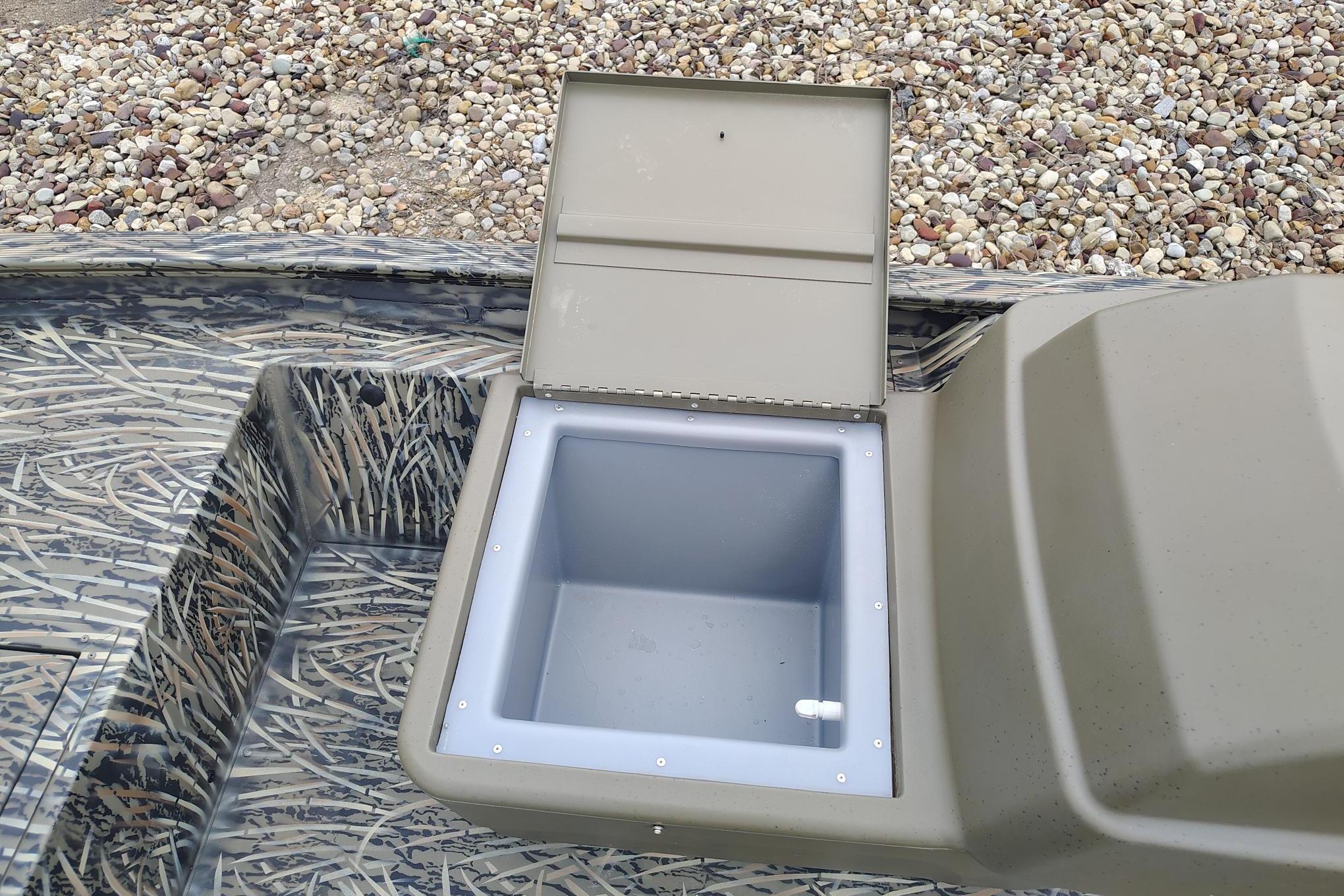 Open storage compartment on 2026 Tracker Grizzly 1754 SC boat, featuring camouflage design.