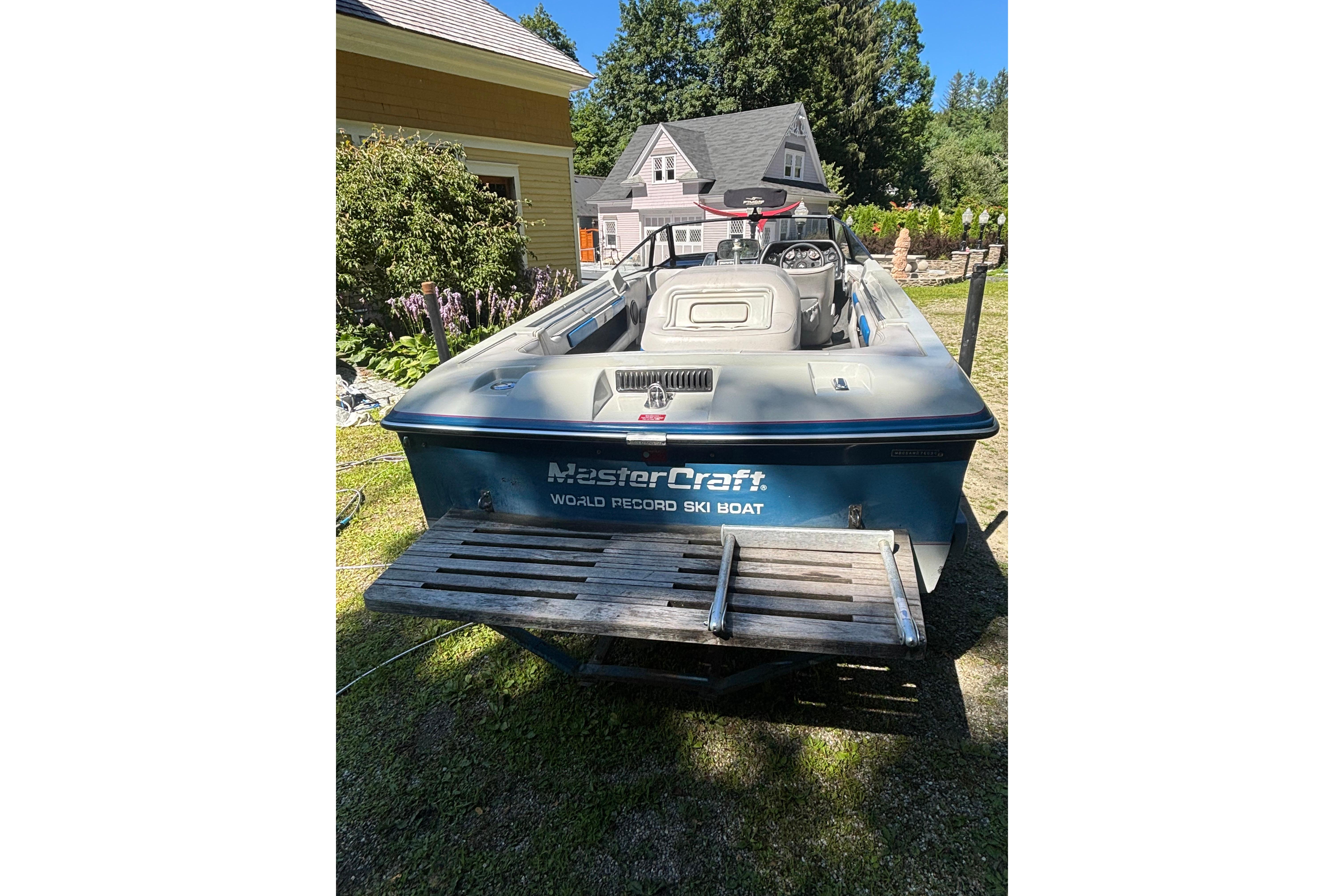 1990 MasterCraft ProStar 190 ski boat parked outdoors, showcasing rear view and surroundings.