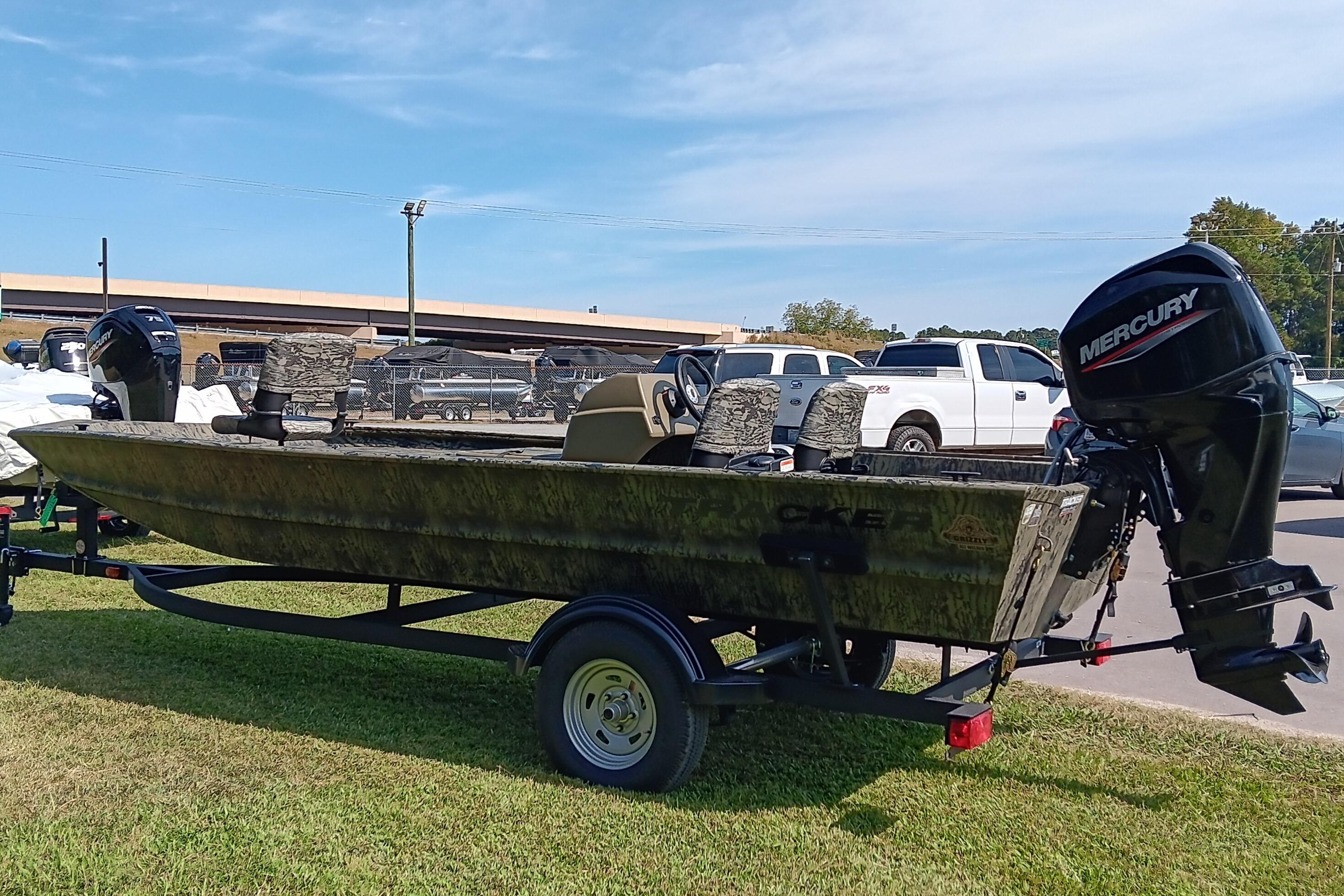2026 Tracker Grizzly 1754 SC boat with Mercury engine on trailer, parked outdoors.