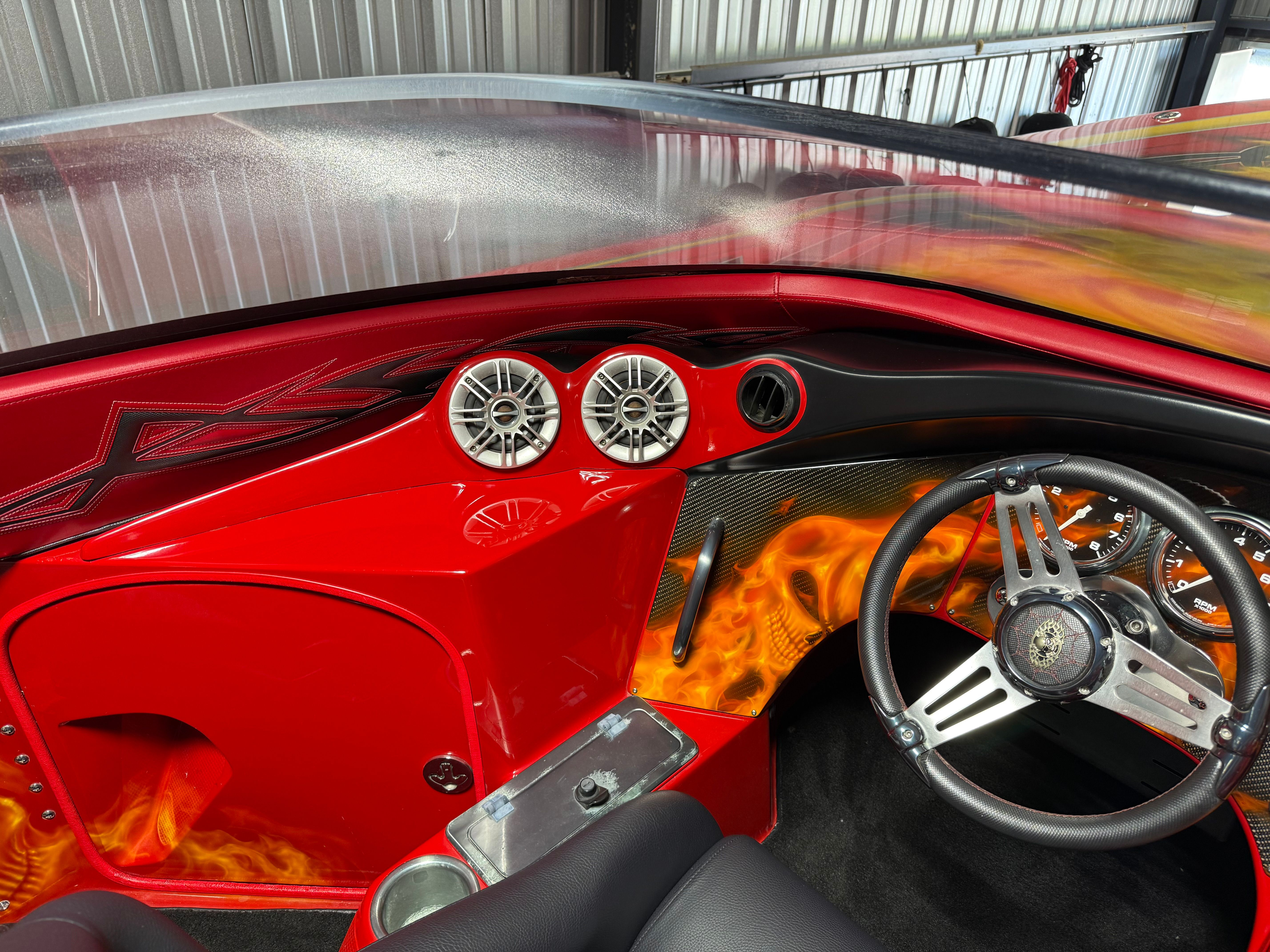 The image shows the cockpit of a 2010 MTI CAT with striking red and black design.