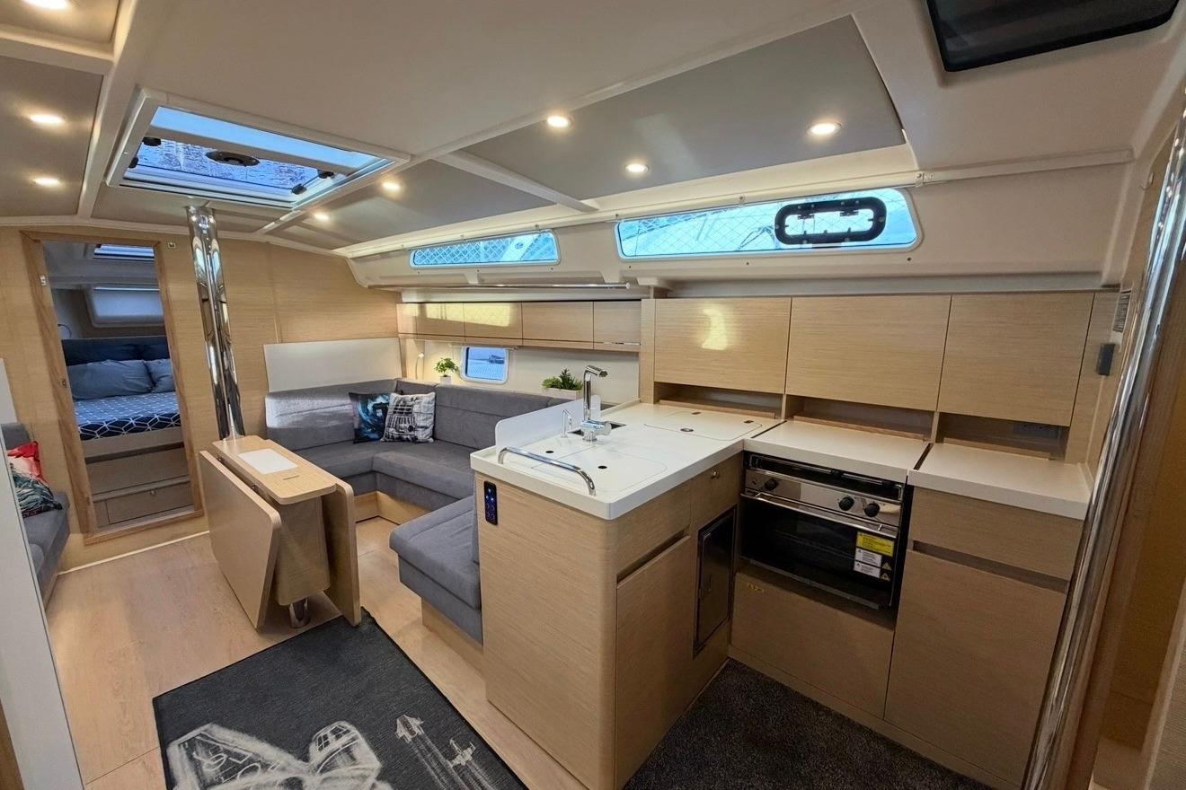 Modern interior of 2022 Hanse 418 yacht with sleek kitchen and cozy seating area.