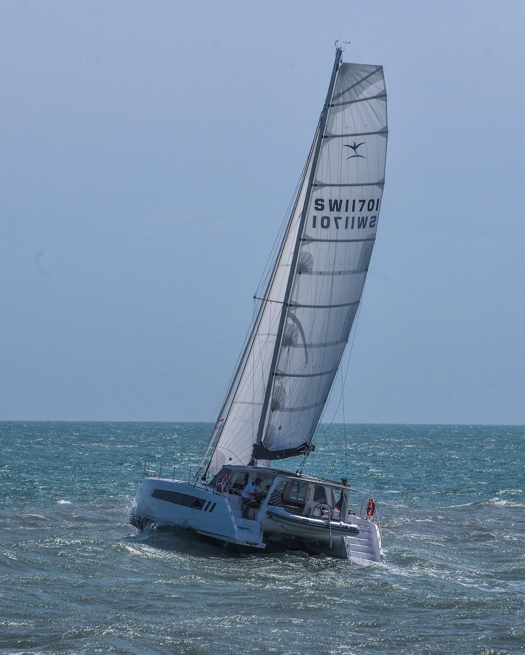 2025 Seawind 1170 catamaran sailing on open sea with full sails.