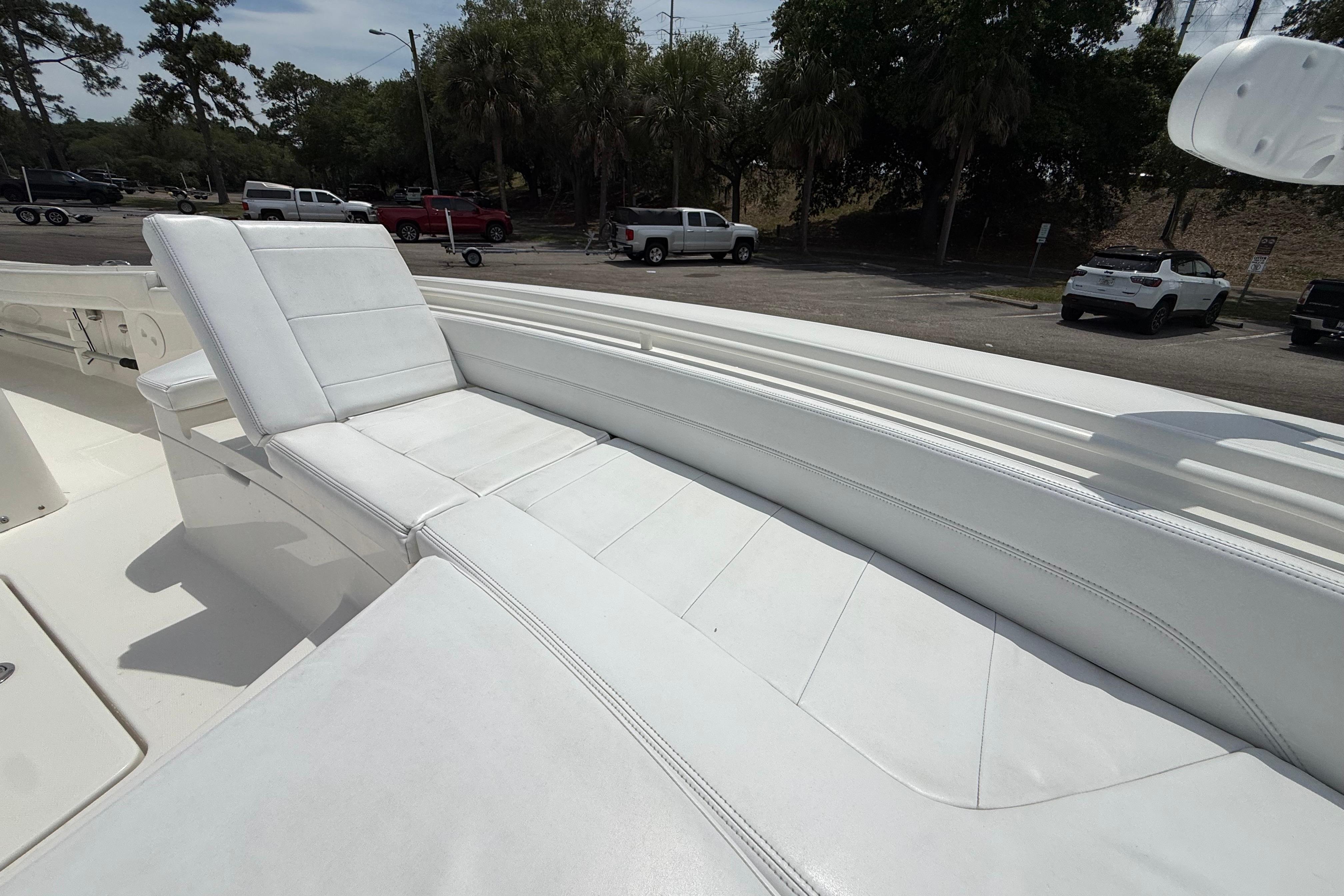 2019 Regulator 26XO boat with white cushioned seating in a parking area.