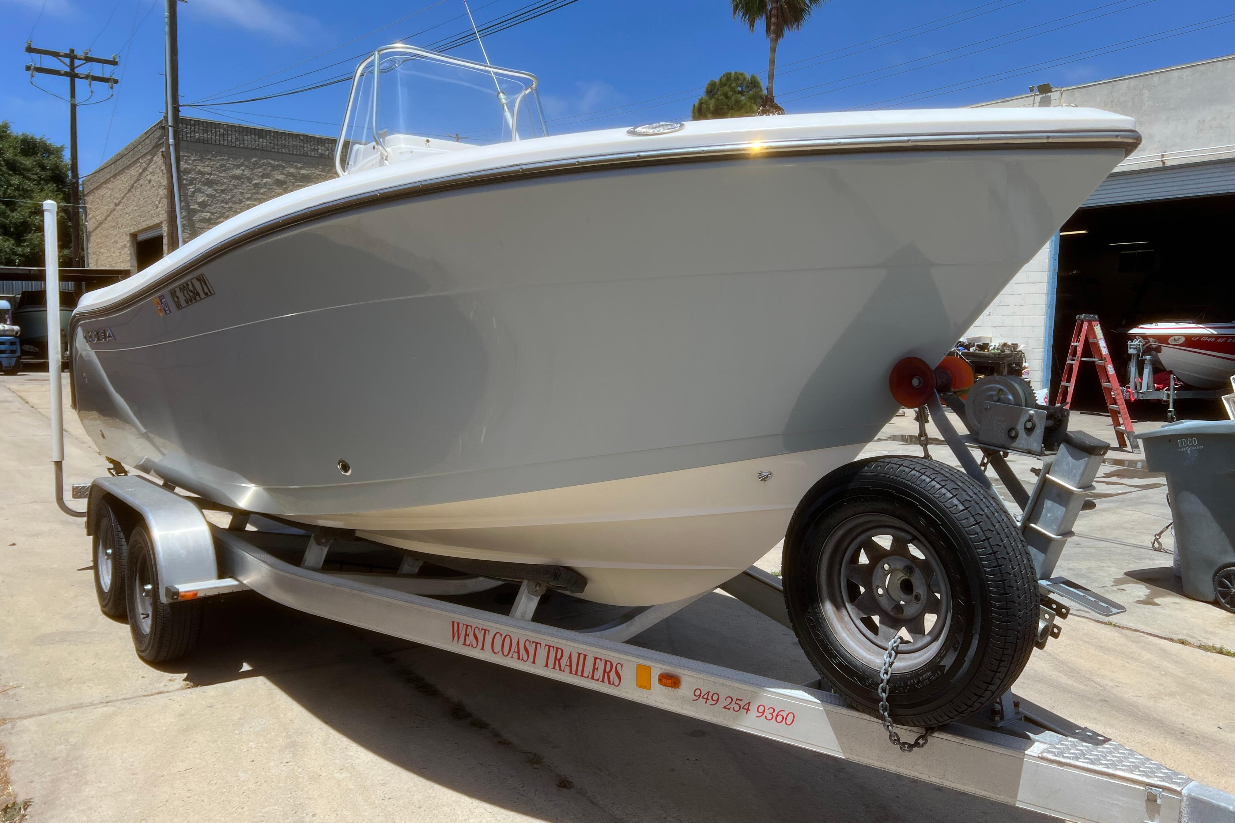 2018 Cobia 201 Center Console boat on trailer, parked outdoors.
