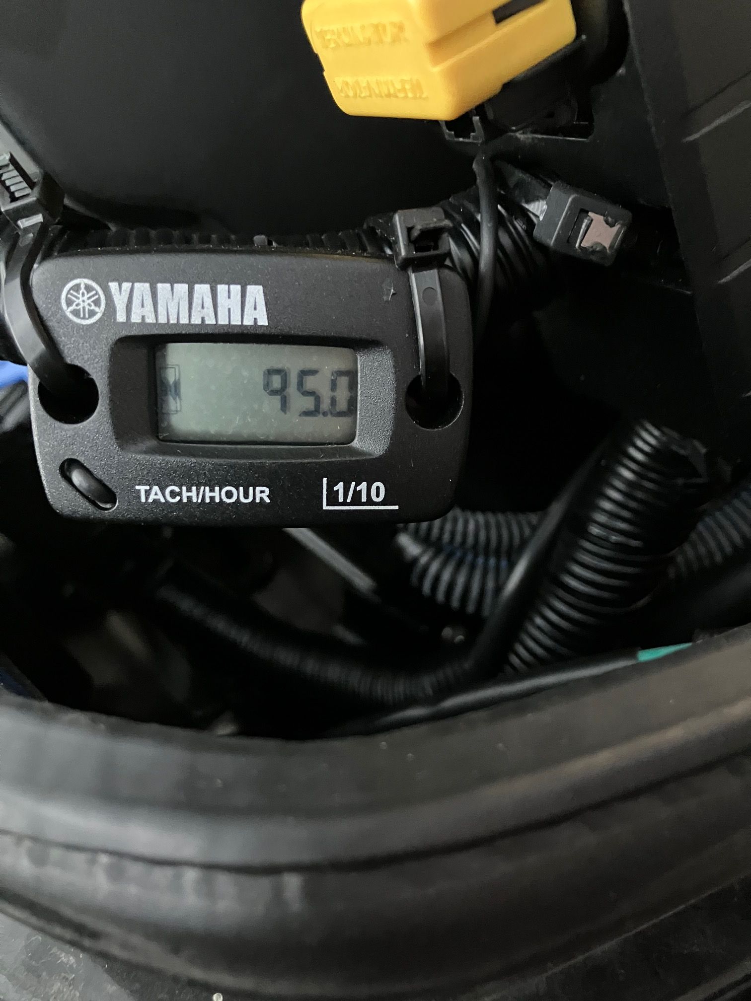 A Yamaha hour meter displays 95 hours, surrounded by cables and a yellow connector.