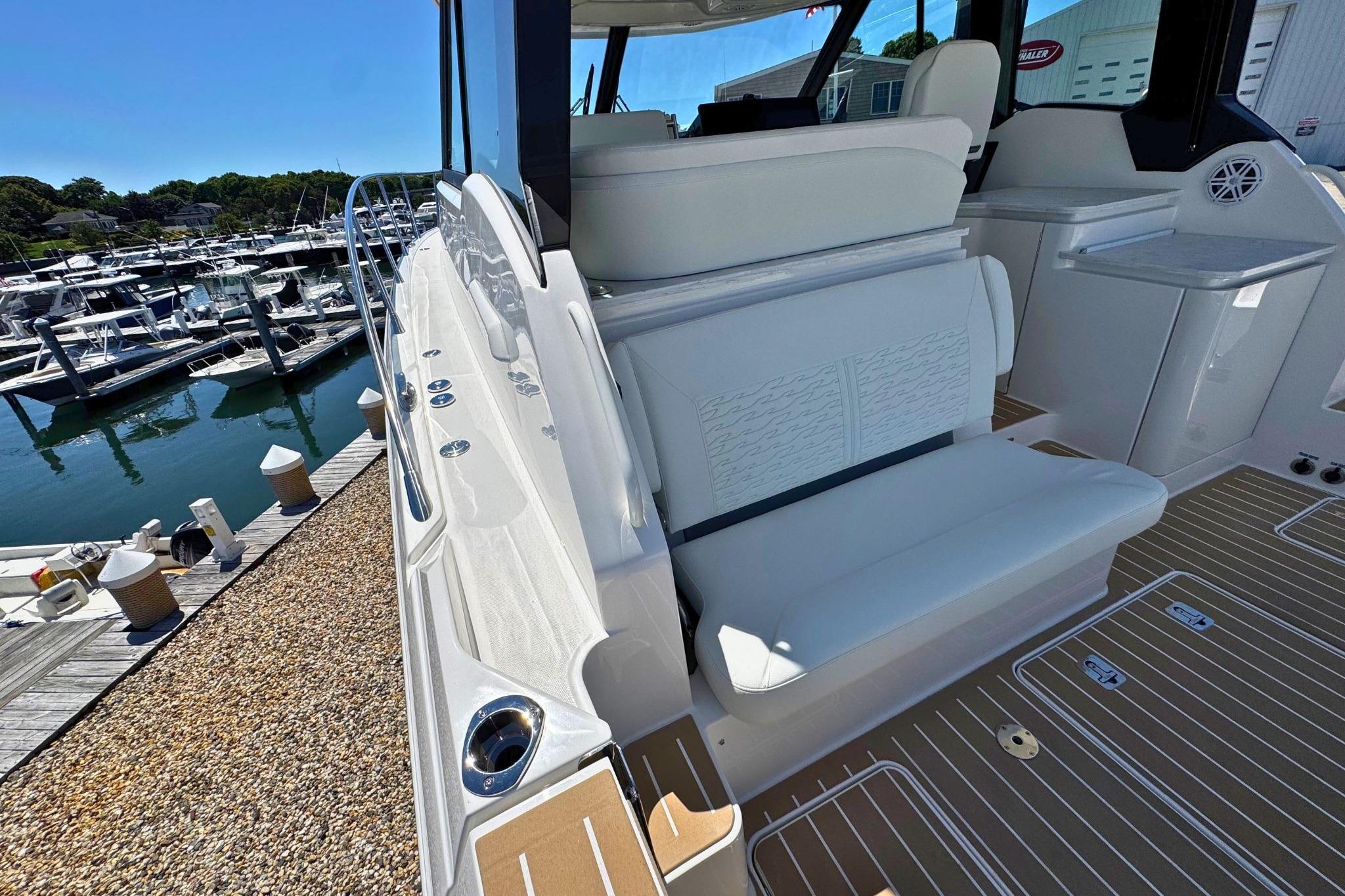 2027 Tiara Yachts 39 LE luxury boat interior with white seating and marina view.