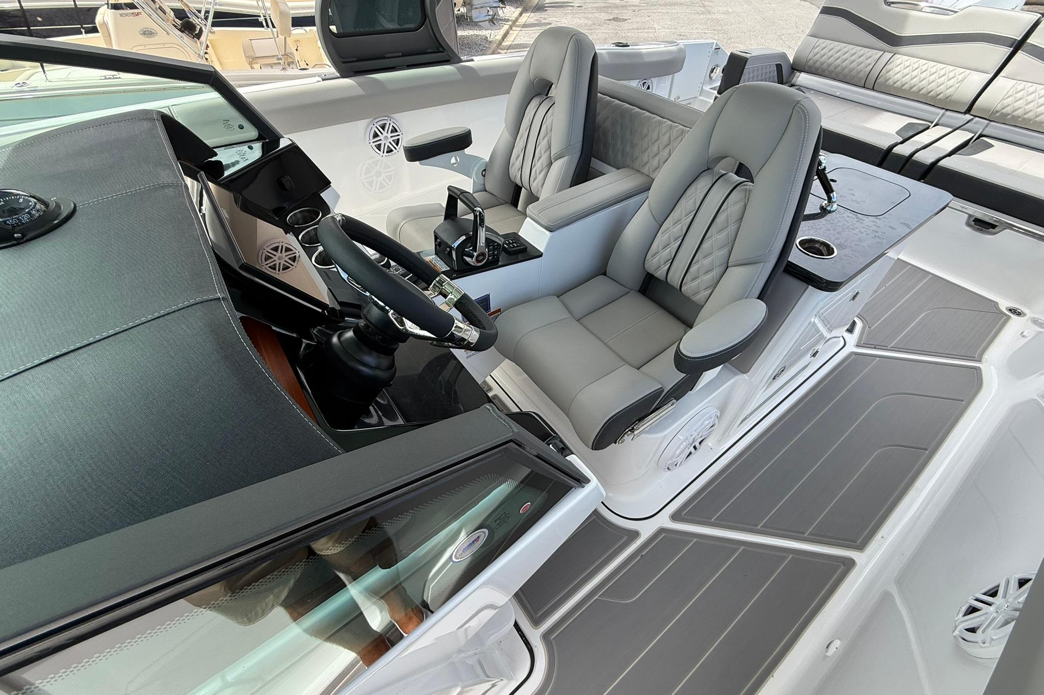 Luxurious interior of 2027 Monterey Elite 30 OB boat with modern seating and steering wheel.
