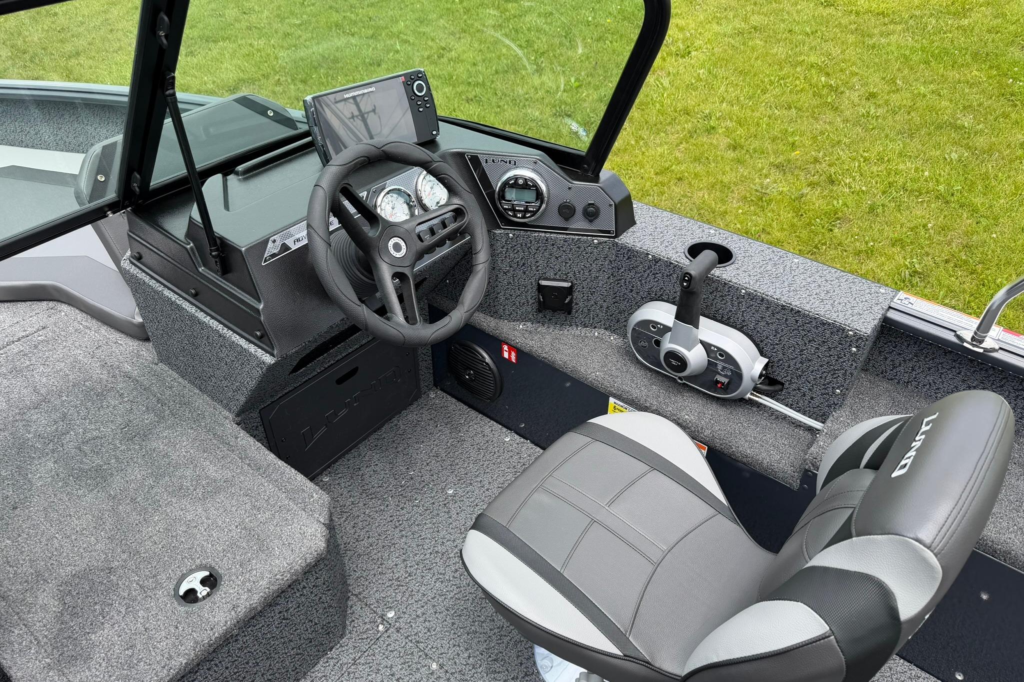Interior of 2027 Lund 1675 Adventure Sport boat with steering wheel and control panel.