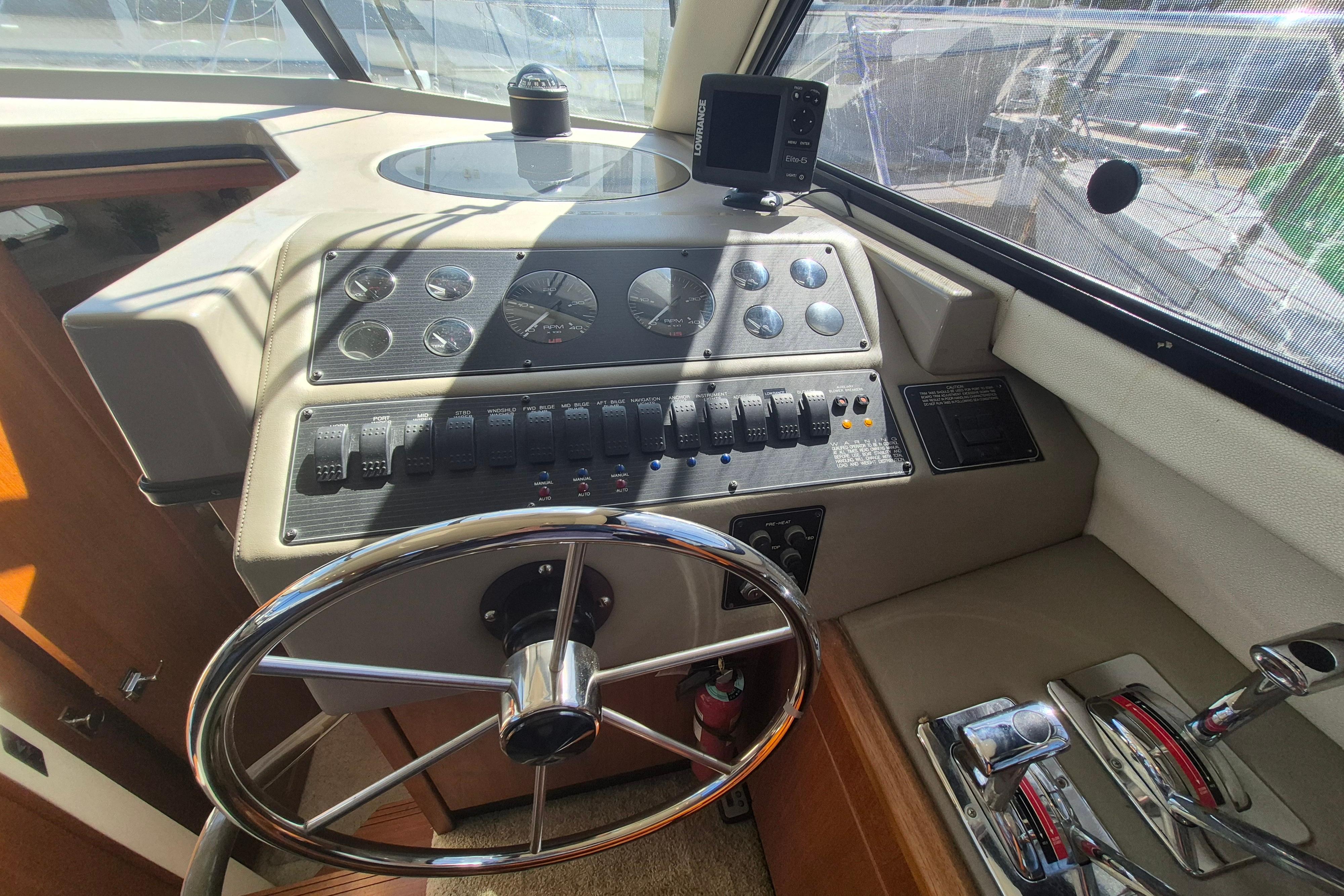 1995 Bayliner 3587 Motoryacht helm with steering wheel, gauges, and controls.