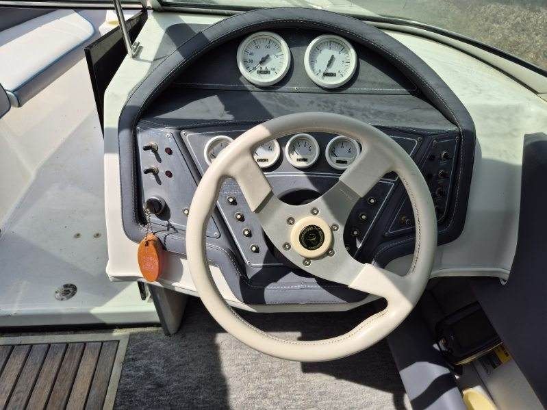 Dashboard of a 1996 Cobalt 220 boat with steering wheel and gauges.